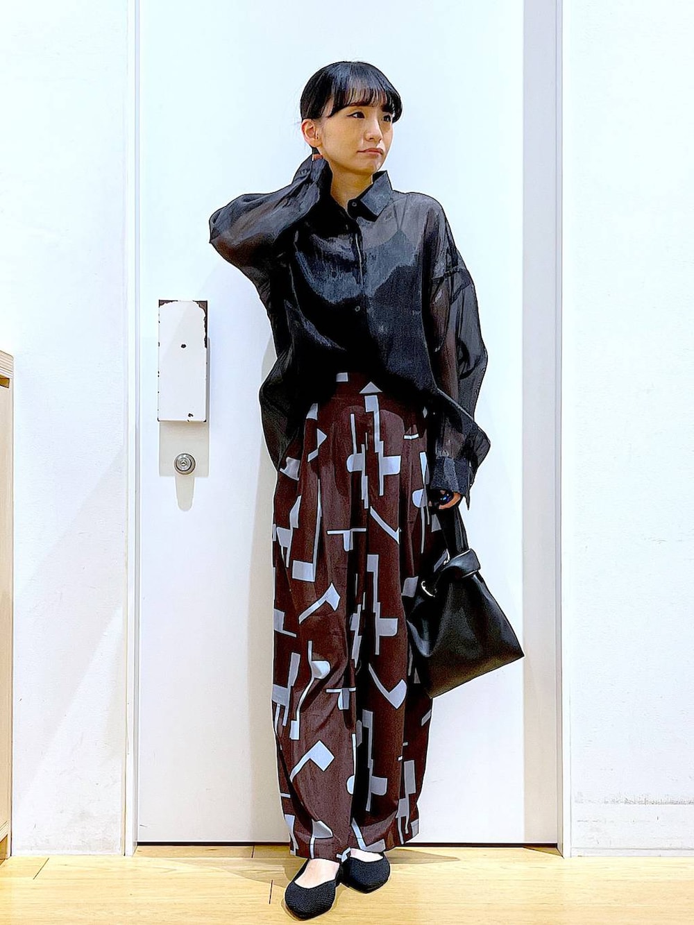 ブラック系のショルダーバッグ、ブラック系のパンプス、ブラウン系のその他パンツを着用したレディースの春コーディネートの2枚目の写真