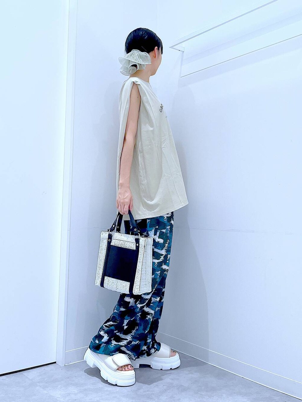 ホワイト系のショルダーバッグ、ホワイト系のサンダル、ベージュ系のTシャツ/カットソーを着用したレディースの夏コーディネートの4枚目の写真