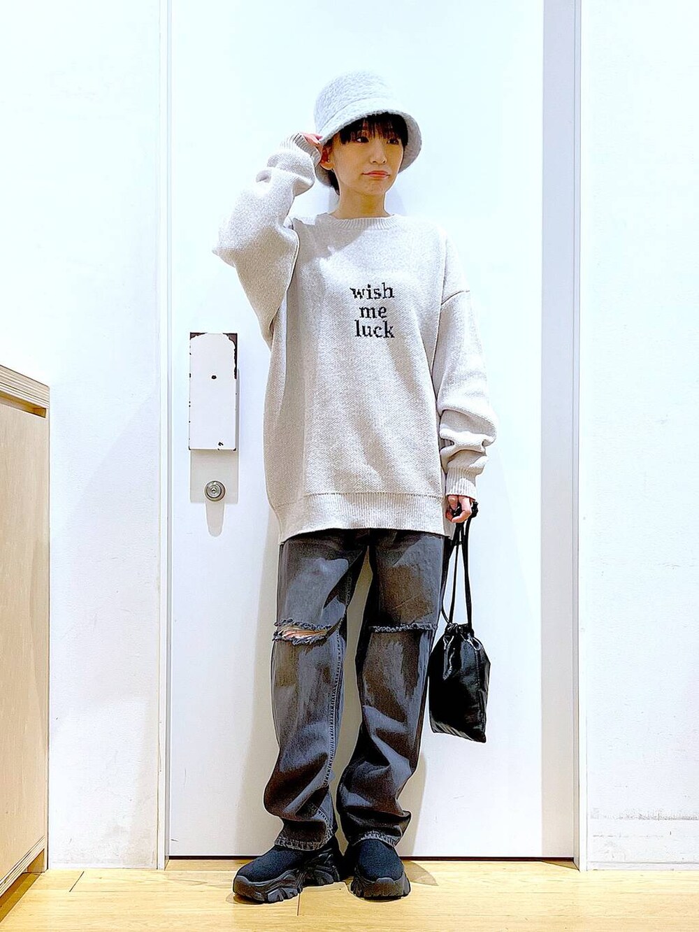 ブラック系のブーツ、ベージュ系のニット/セーター、ブルー系のデニムパンツを着用したレディースの冬コーディネートの2枚目の写真