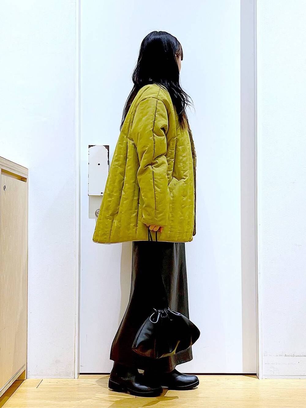 ブラック系のブーツ、ブラック系のショルダーバッグ、ブラック系のニット/セーターを着用したレディースの冬コーディネートの4枚目の写真