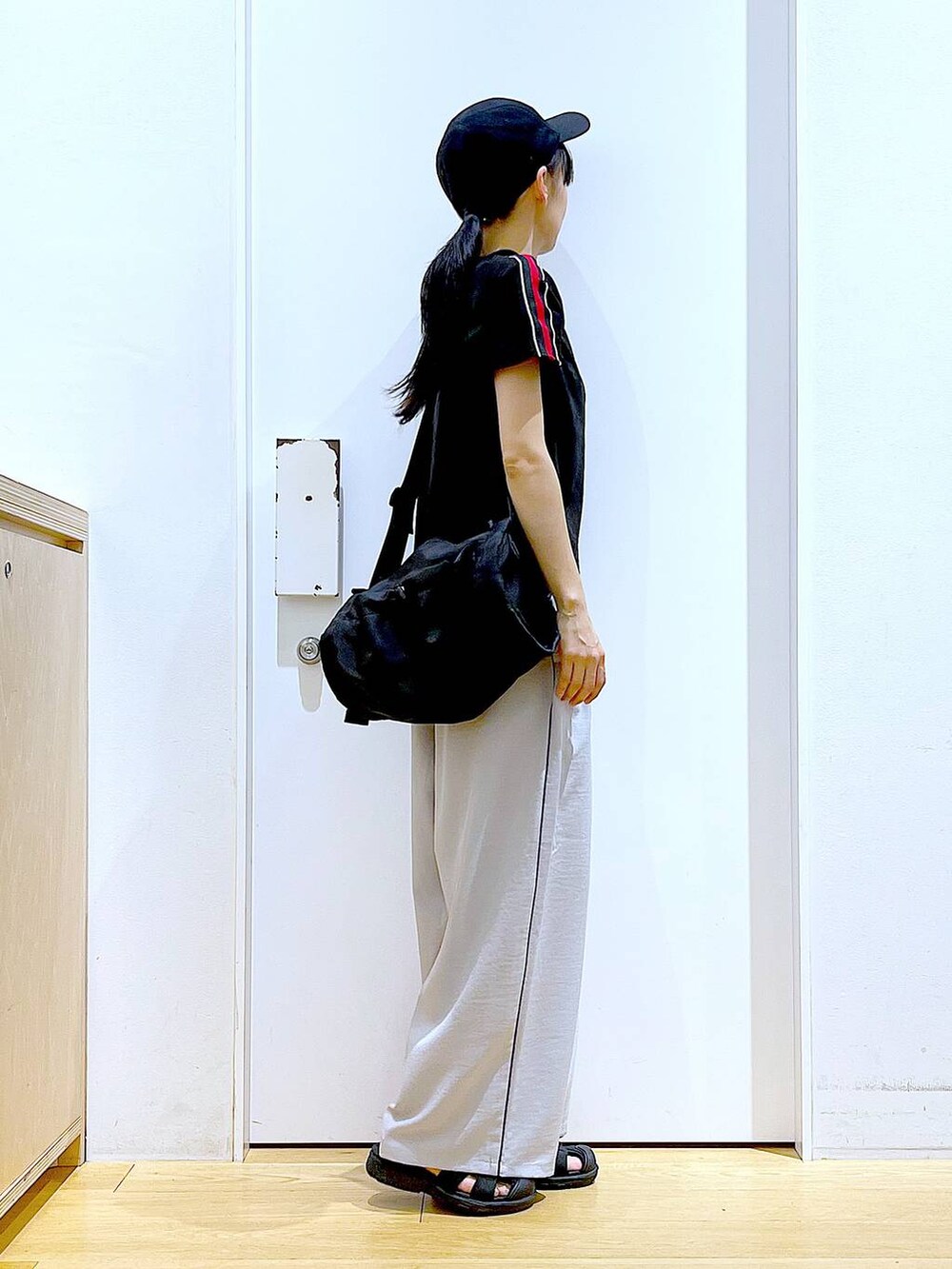 ブラック系のショルダーバッグ、ブラック系のスリッポン、ブラック系のTシャツ/カットソーを着用したレディースの春コーディネートの4枚目の写真