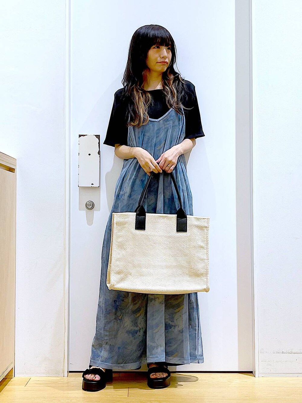 ブラック系のサンダル、ブラック系のその他パンツ、ホワイト系のトートバッグを着用したレディースの夏コーディネートの2枚目の写真