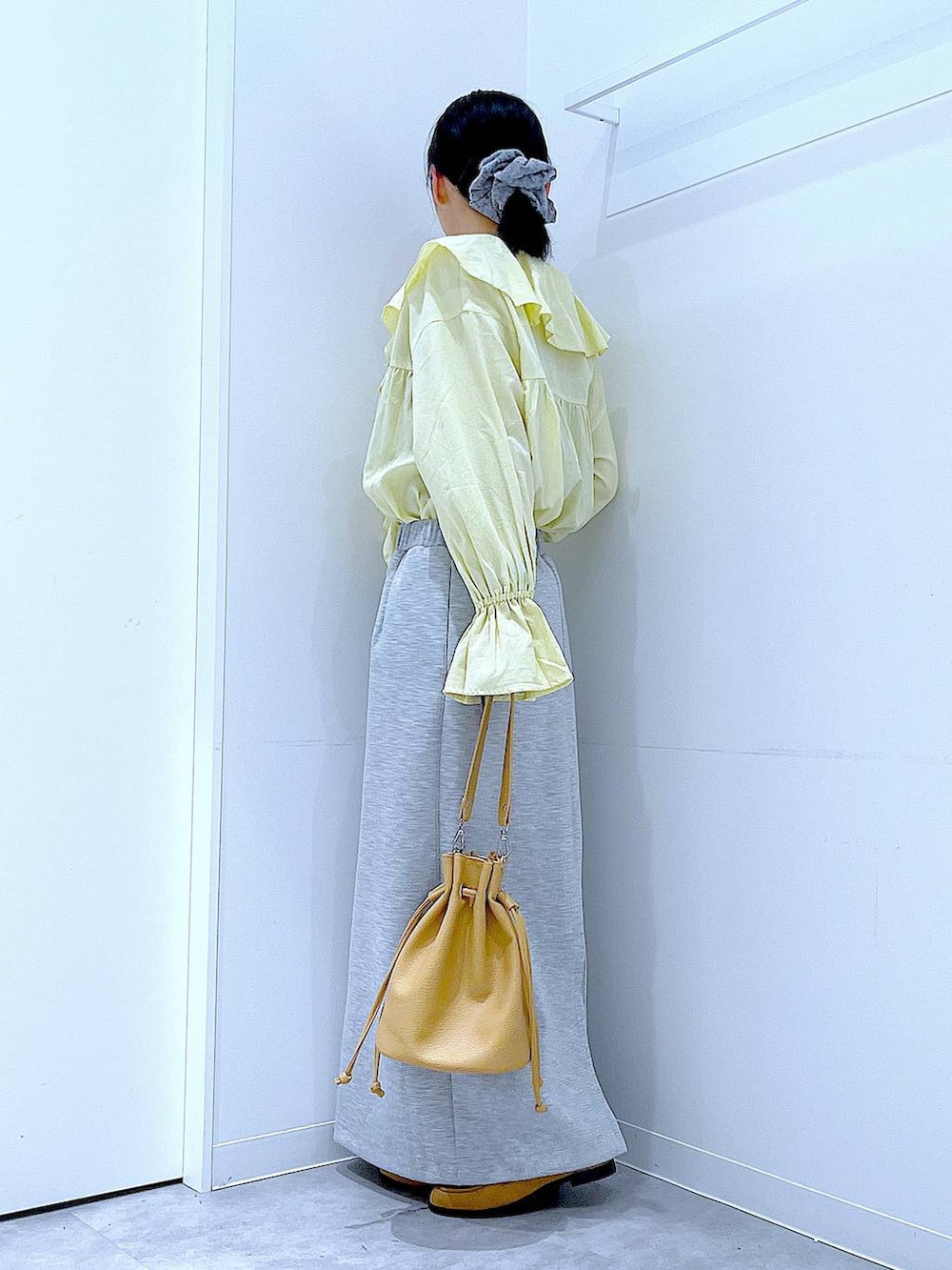 グレー系のスカート、ベージュ系のローファー、ブラウン系のショルダーバッグを着用したレディースの冬コーディネートの3枚目の写真