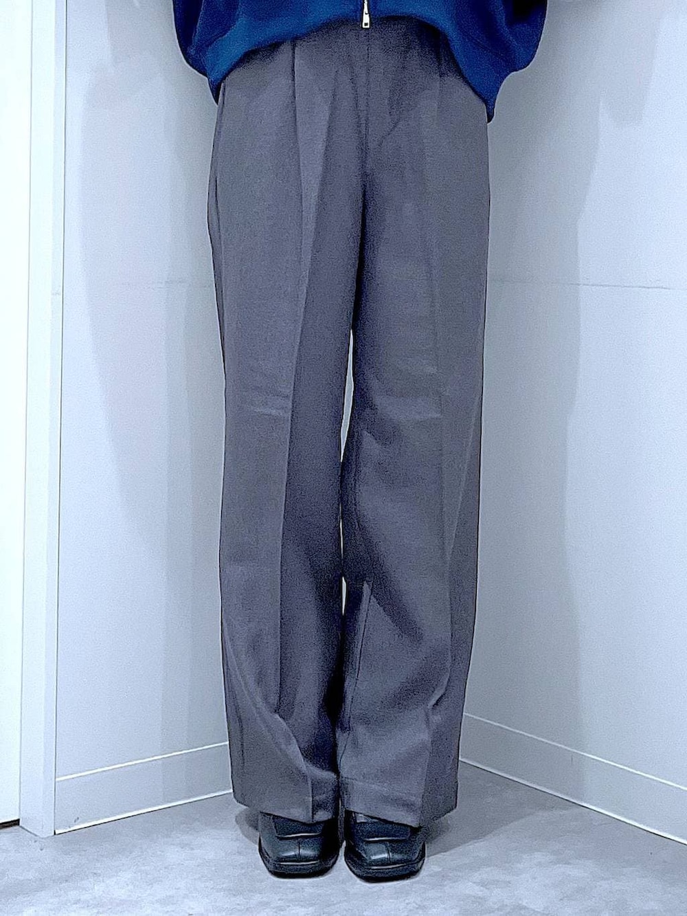 ブラック系のショルダーバッグ、ブラック系のブーツ、グレー系のスラックスを着用したレディースの冬コーディネートの8枚目の写真