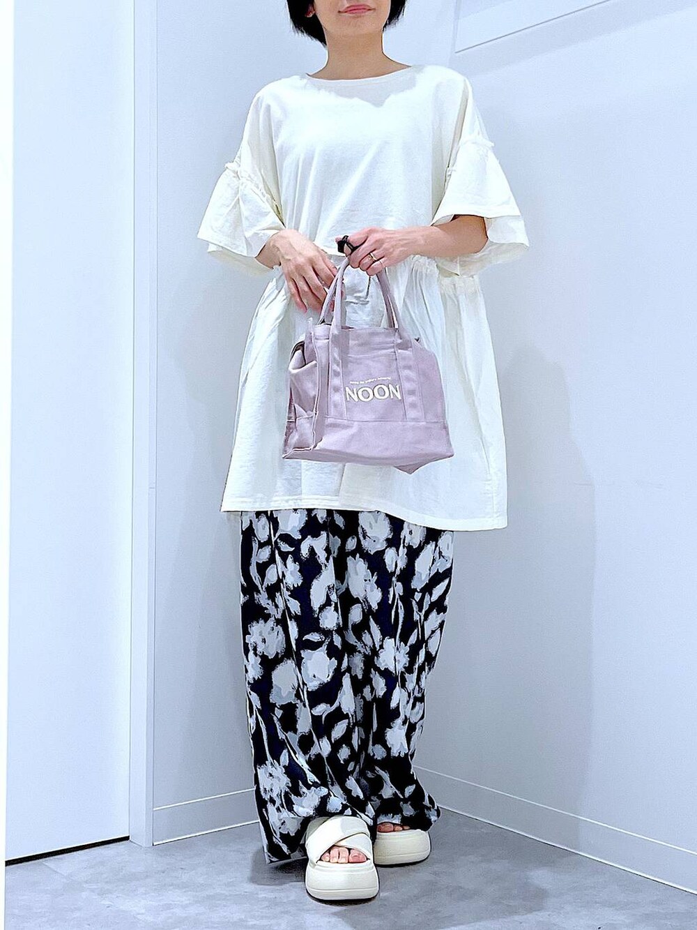 ホワイト系のサンダル、ブラック系のその他パンツ、グレー系のトートバッグを着用したレディースの夏コーディネートの6枚目の写真