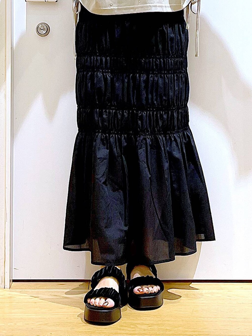 ブラック系のサンダル、ブラック系のスカート、ブラック系のトートバッグを着用したレディースの夏コーディネートの8枚目の写真