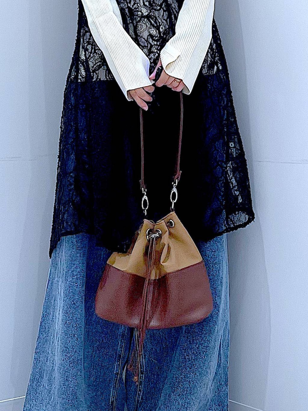 ベージュ系のニット/セーター、ブルー系のデニムパンツ、ベージュ系のショルダーバッグを着用したレディースの秋コーディネートの9枚目の写真