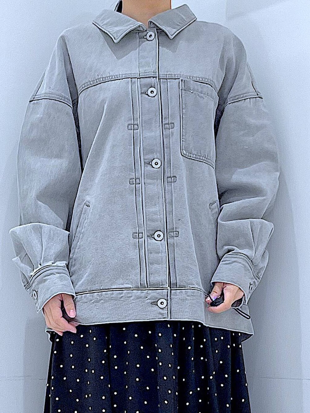 グレー系のデニムジャケット、ホワイト系のショルダーバッグ、グレー系のシュシュを着用したレディースの春コーディネートの7枚目の写真