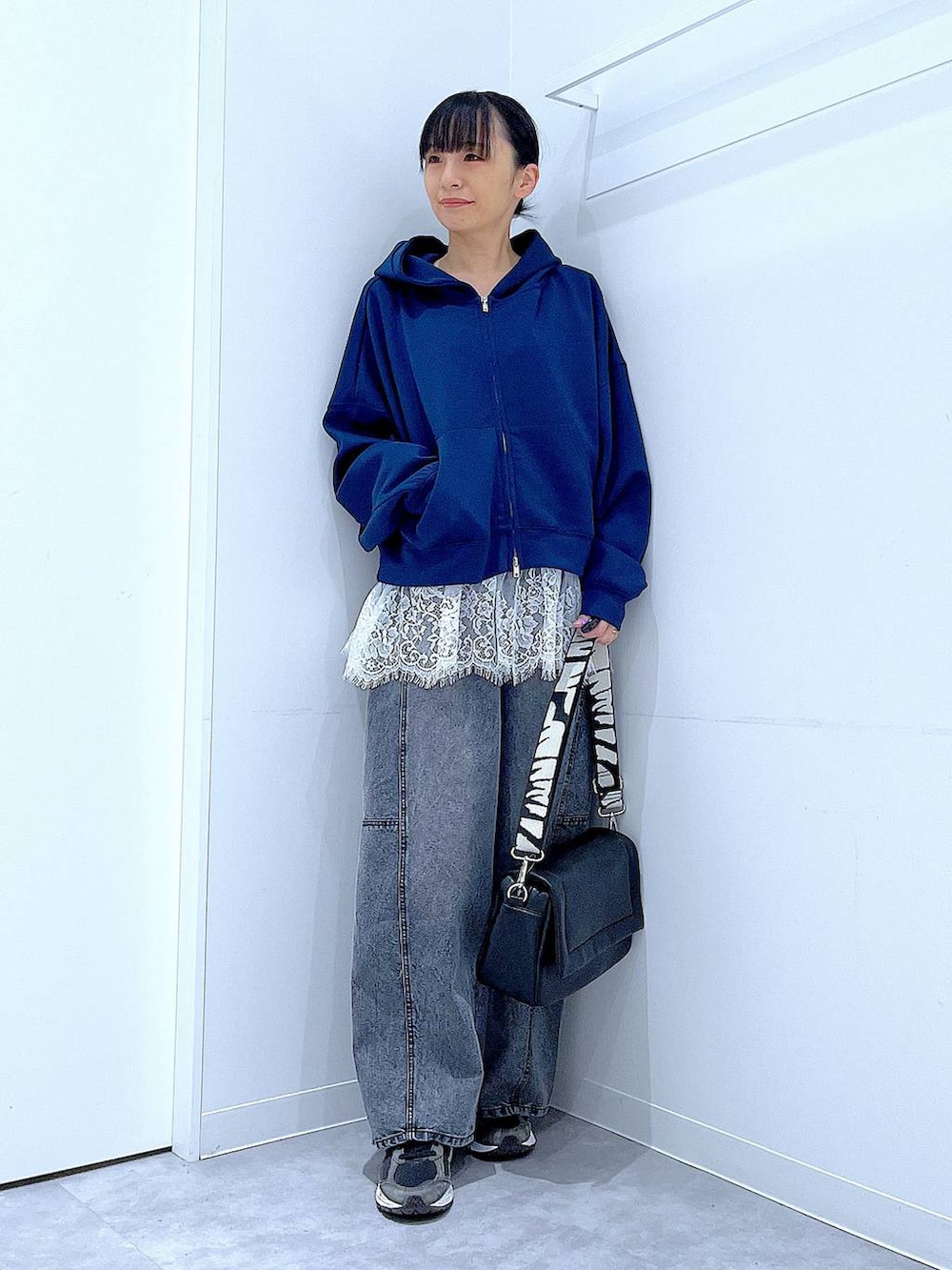 ブラック系のショルダーバッグ、ホワイト系のTシャツ/カットソー、ブラック系のデニムパンツを着用したレディースの春コーディネートの2枚目の写真