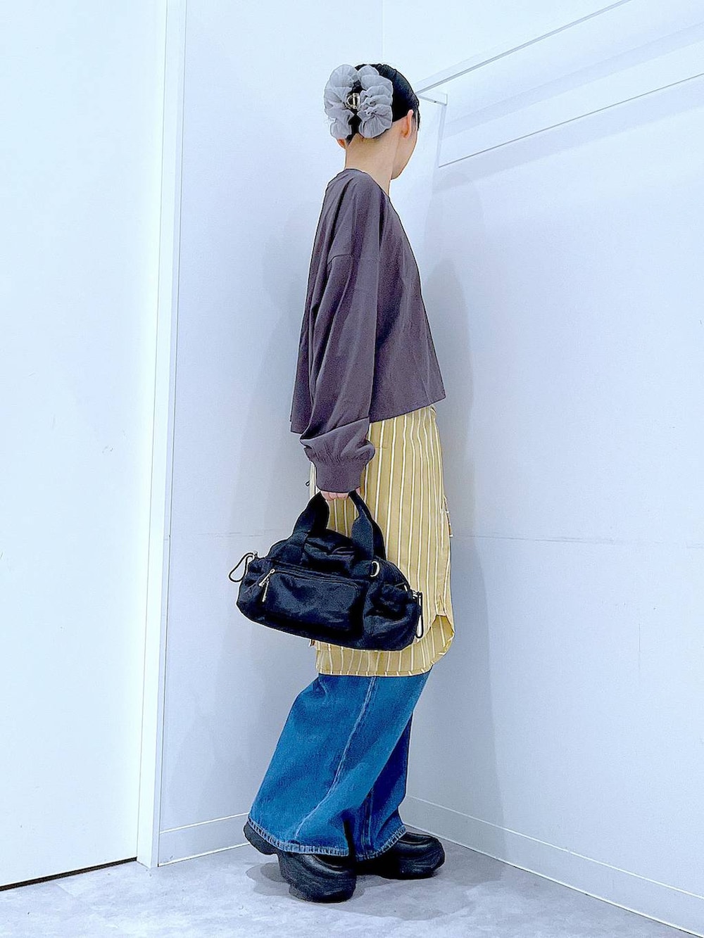 ブルー系のデニムパンツ、イエロー系のシャツ/ブラウス、グレー系のTシャツ/カットソーを着用したレディースの秋コーディネートの4枚目の写真