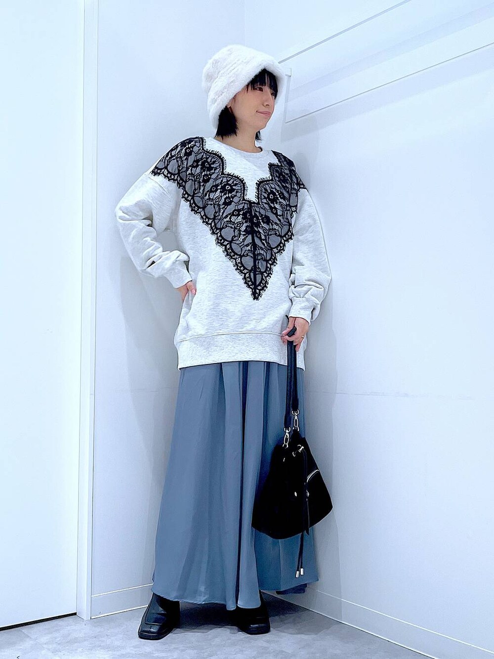 ブラック系のショルダーバッグ、ブラック系のブーツ、ベージュ系のスウェットを着用したレディースの冬コーディネートの2枚目の写真