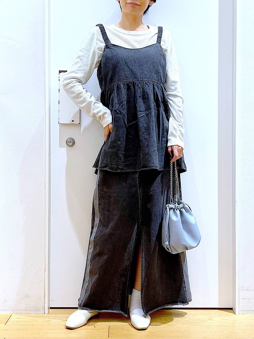 ブルー系のショルダーバッグ、ホワイト系のパンプス、ブラック系のデニムスカートを着用したレディースの春コーディネートの6枚目の写真