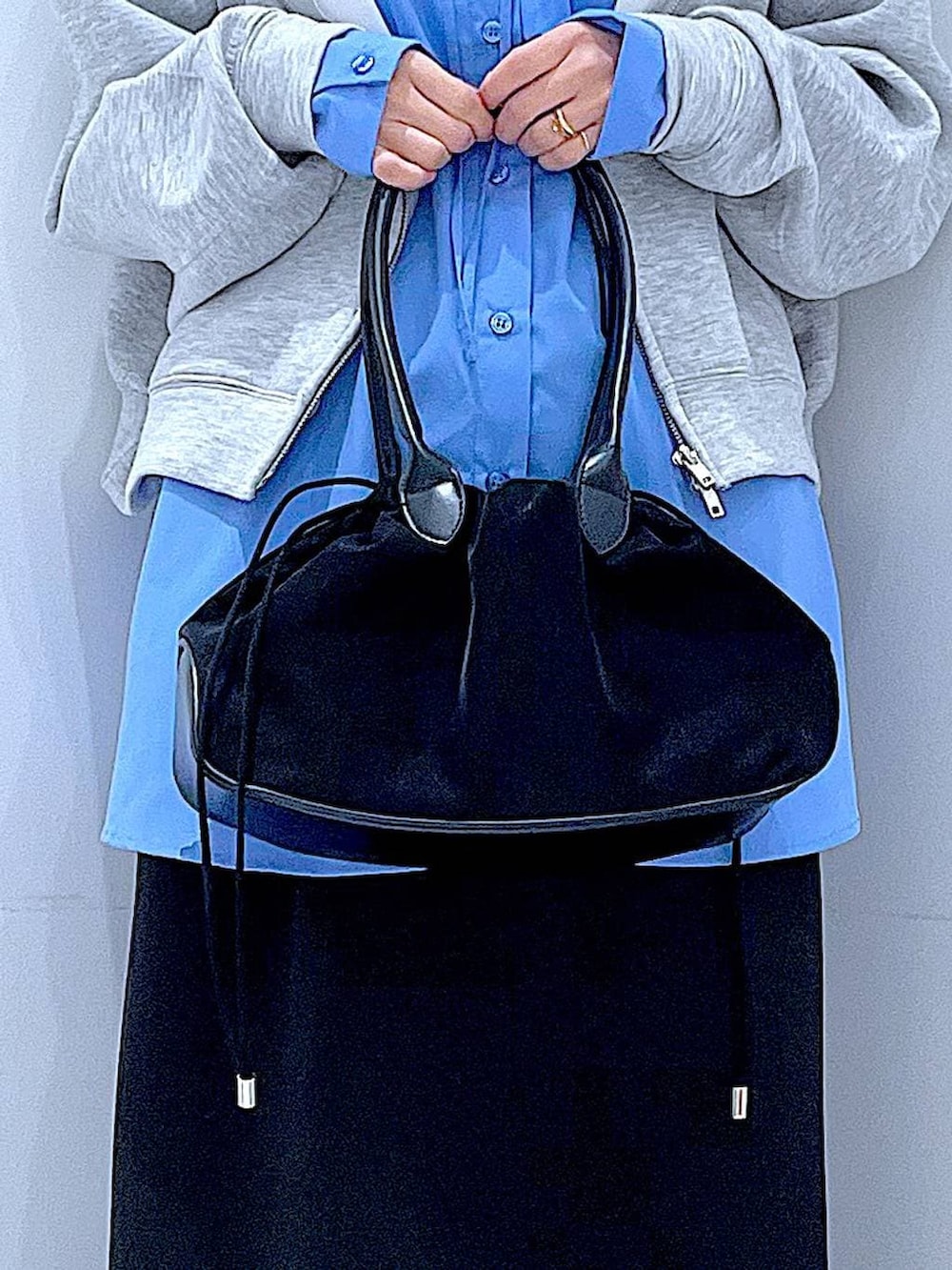 ブラック系のハンドバッグ、ブラック系のスカート、ブラック系のサンダルを着用したレディースの冬コーディネートの9枚目の写真