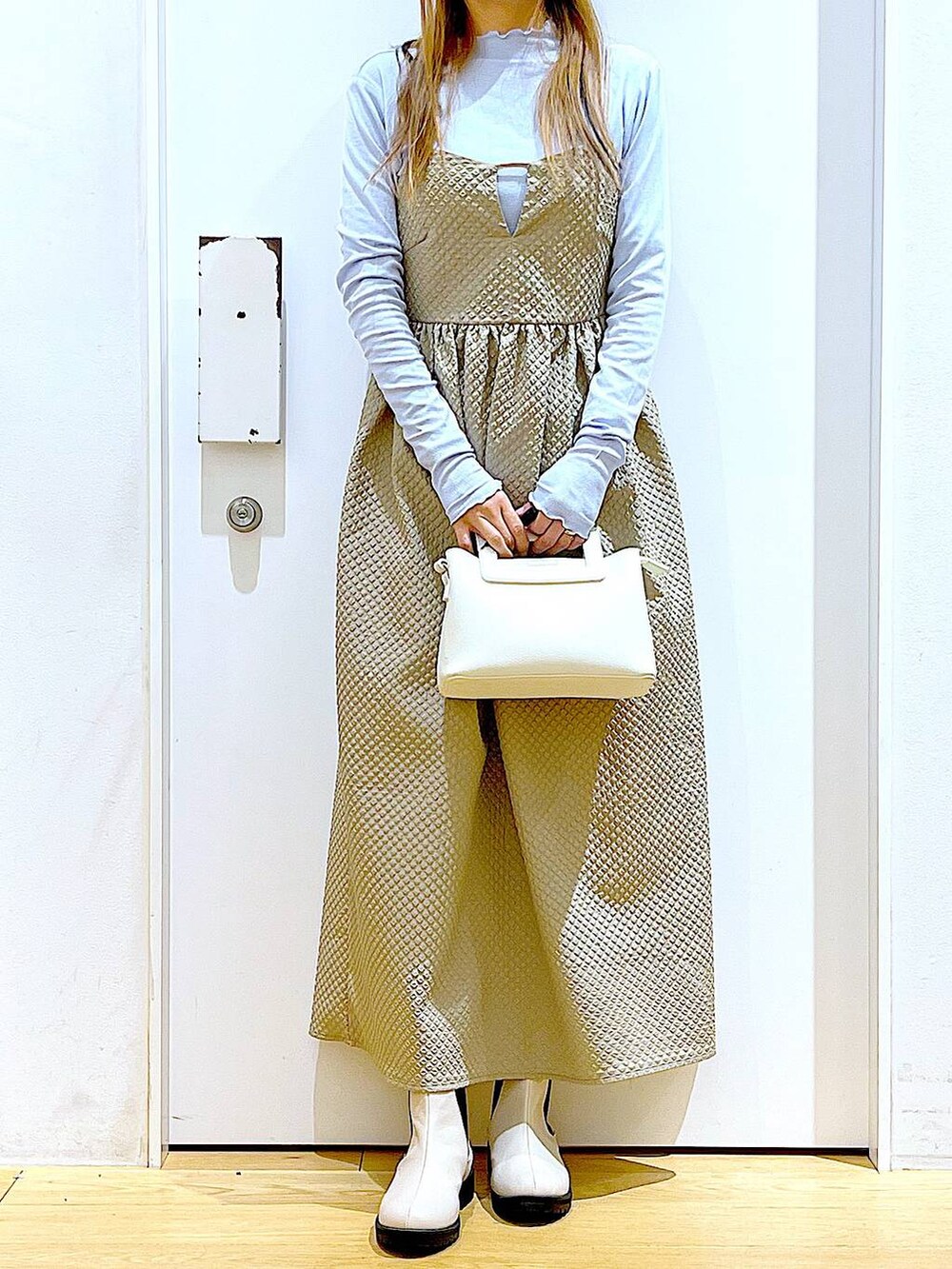 ブルー系のTシャツ/カットソー、ブラウン系のワンピース、ベージュ系のブーツを着用したレディースの冬コーディネートの6枚目の写真