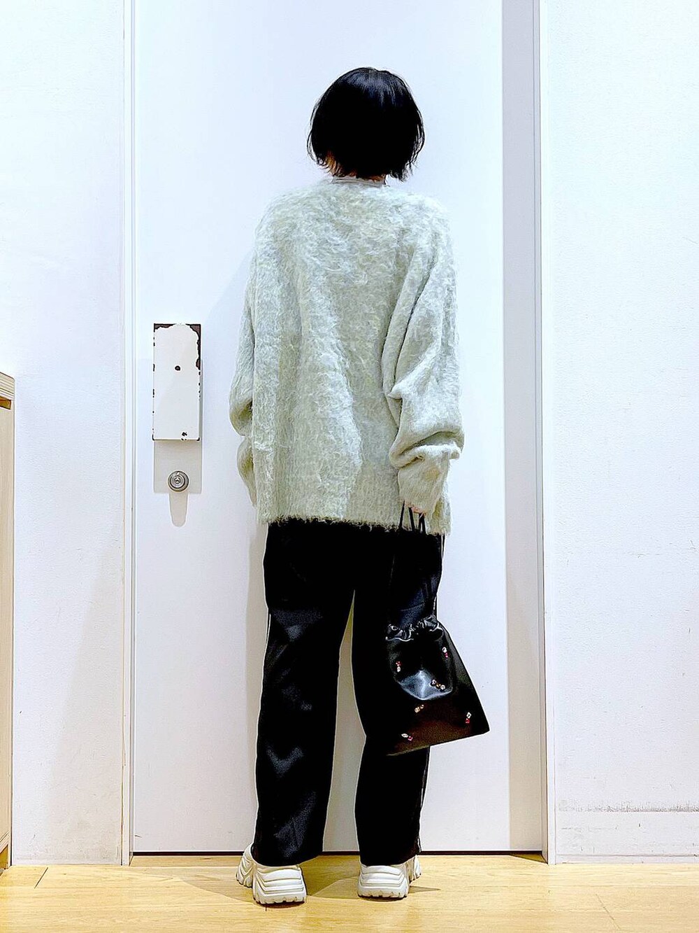 グリーン系のカーディガン/ボレロ、ブラック系のスラックス、ブラック系のショルダーバッグを着用したレディースの冬コーディネートの5枚目の写真