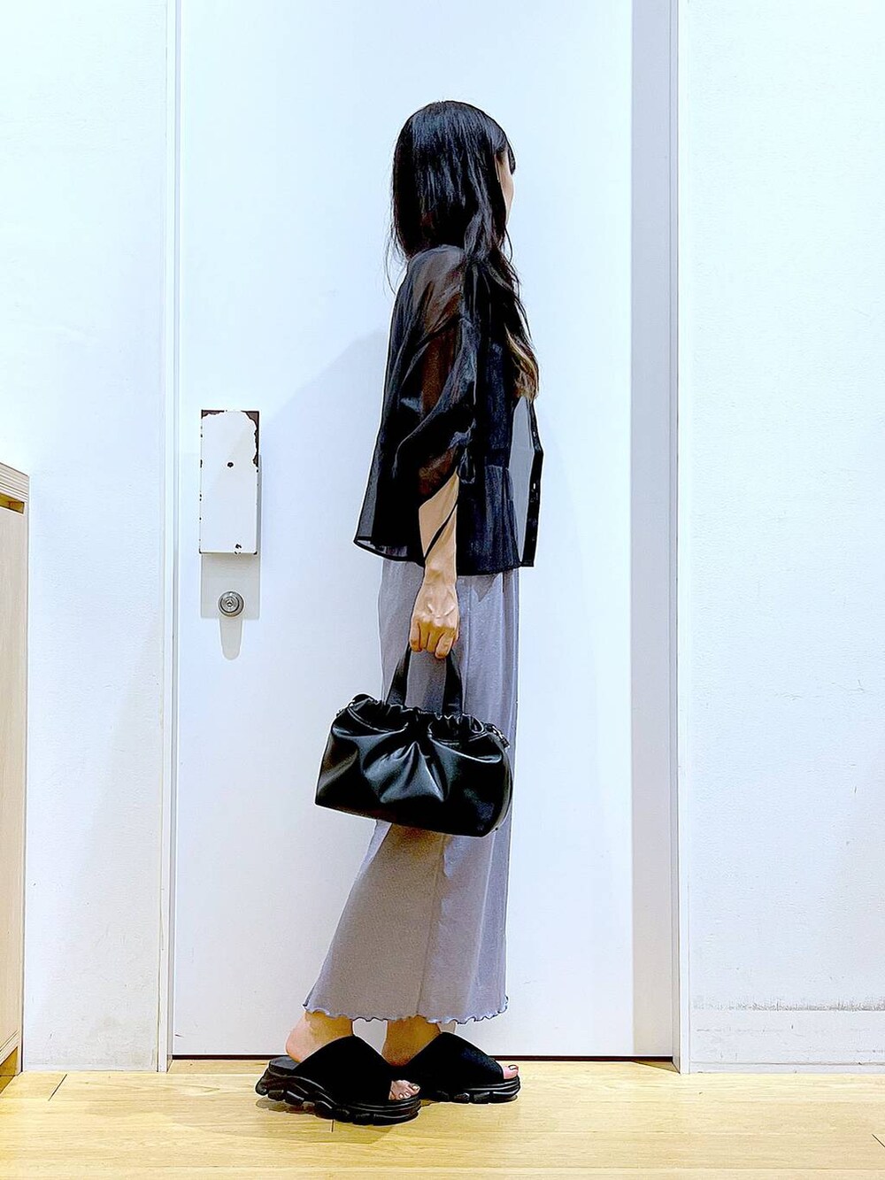 パープル系のスカート、ブラック系のサンダル、ブラック系のニット/セーターを着用したレディースの夏コーディネートの4枚目の写真