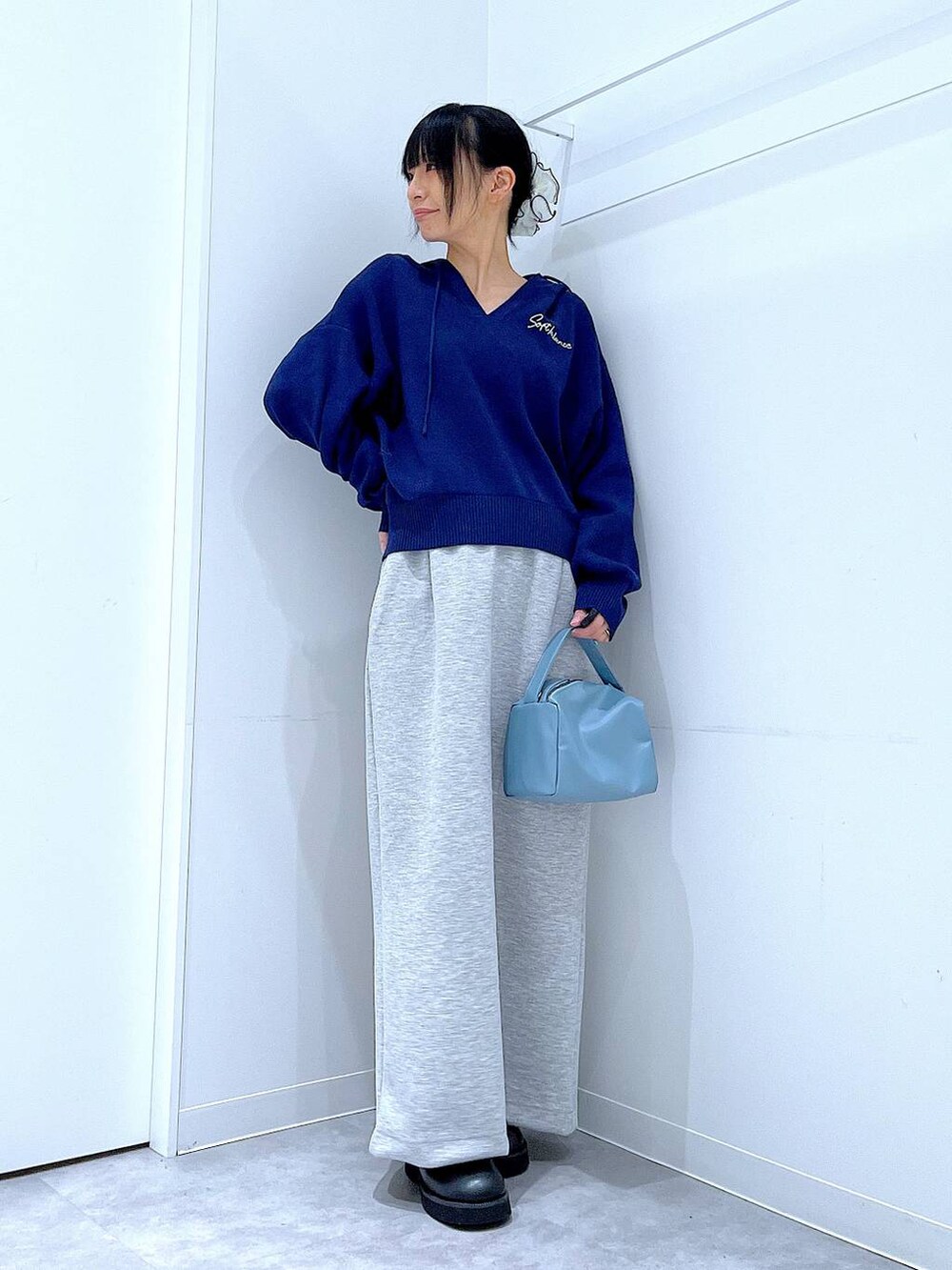 ブルー系のショルダーバッグ、ブラック系のサンダル、グレー系のスカートを着用したレディースの春コーディネートの2枚目の写真