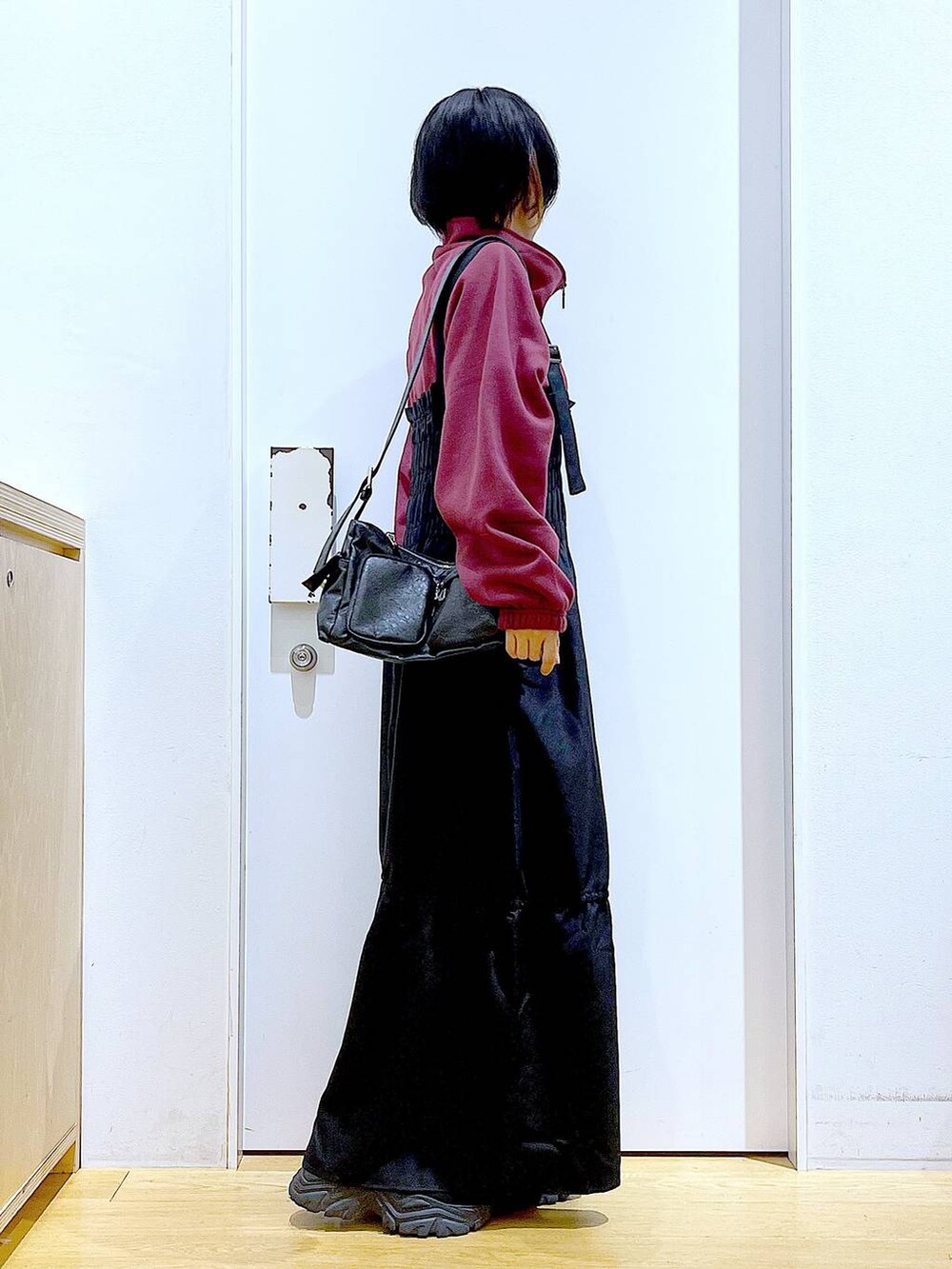 ブラック系のブーツ、ブラック系のショルダーバッグ、ブラック系のワンピースを着用したレディースの秋コーディネートの4枚目の写真