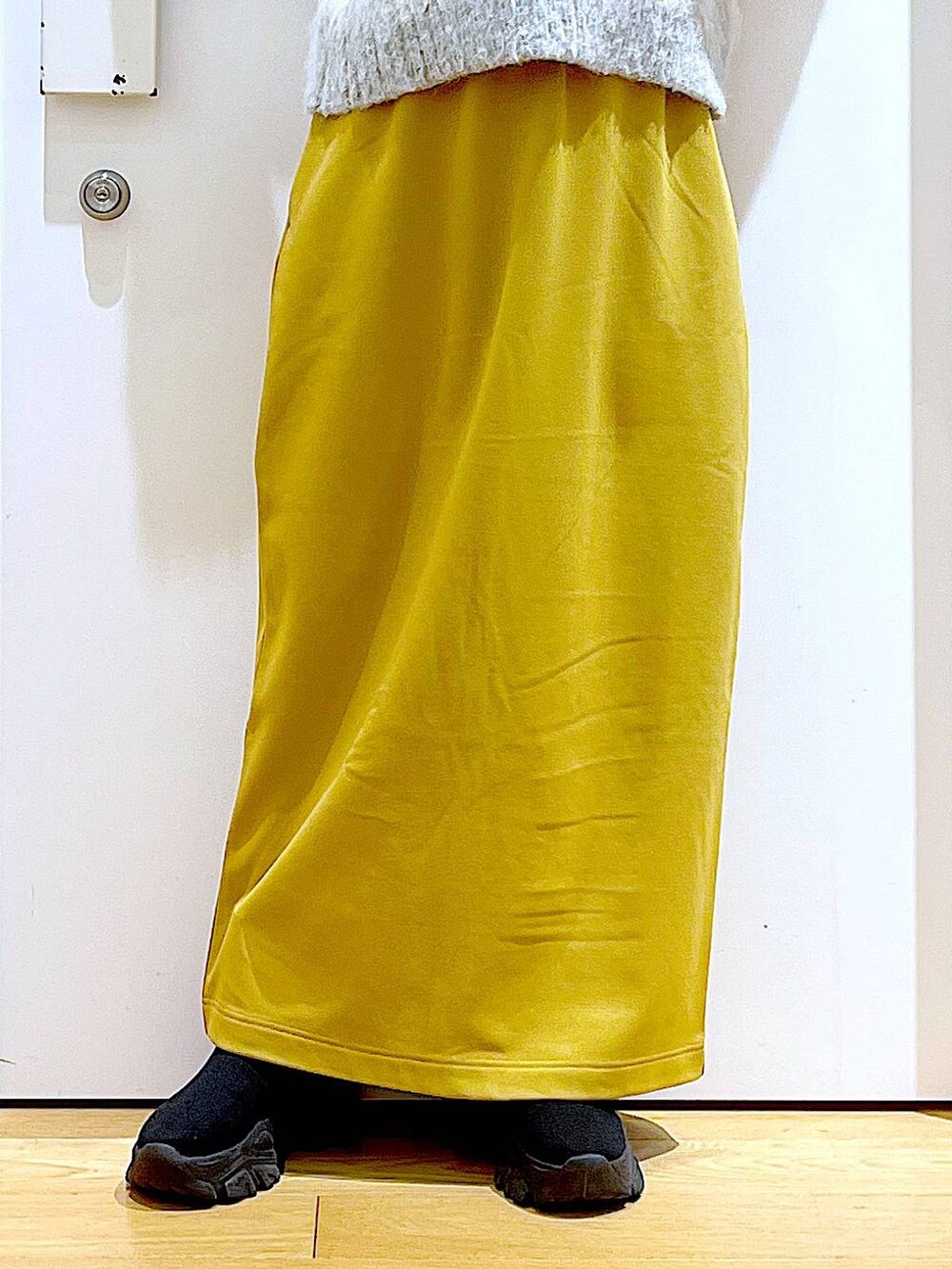 ブラック系のブーツ、イエロー系のスカート、その他のショルダーバッグを着用したレディースの冬コーディネートの8枚目の写真