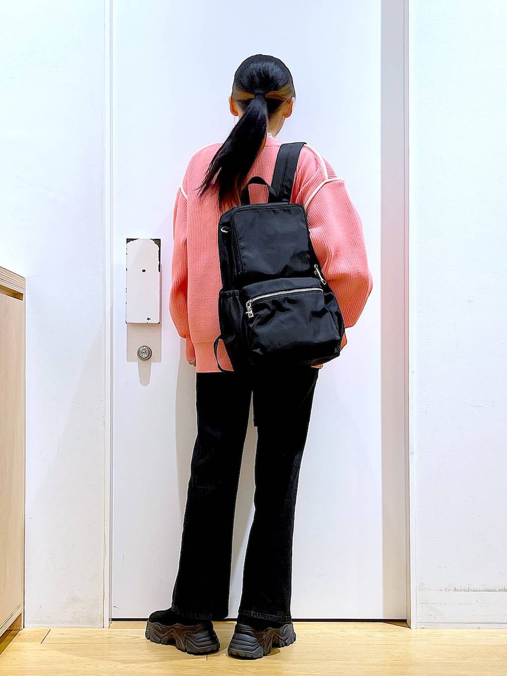 グレー系のデニムパンツ、ホワイト系のTシャツ/カットソー、ブラック系のバックパック/リュックを着用したレディースの冬コーディネートの5枚目の写真