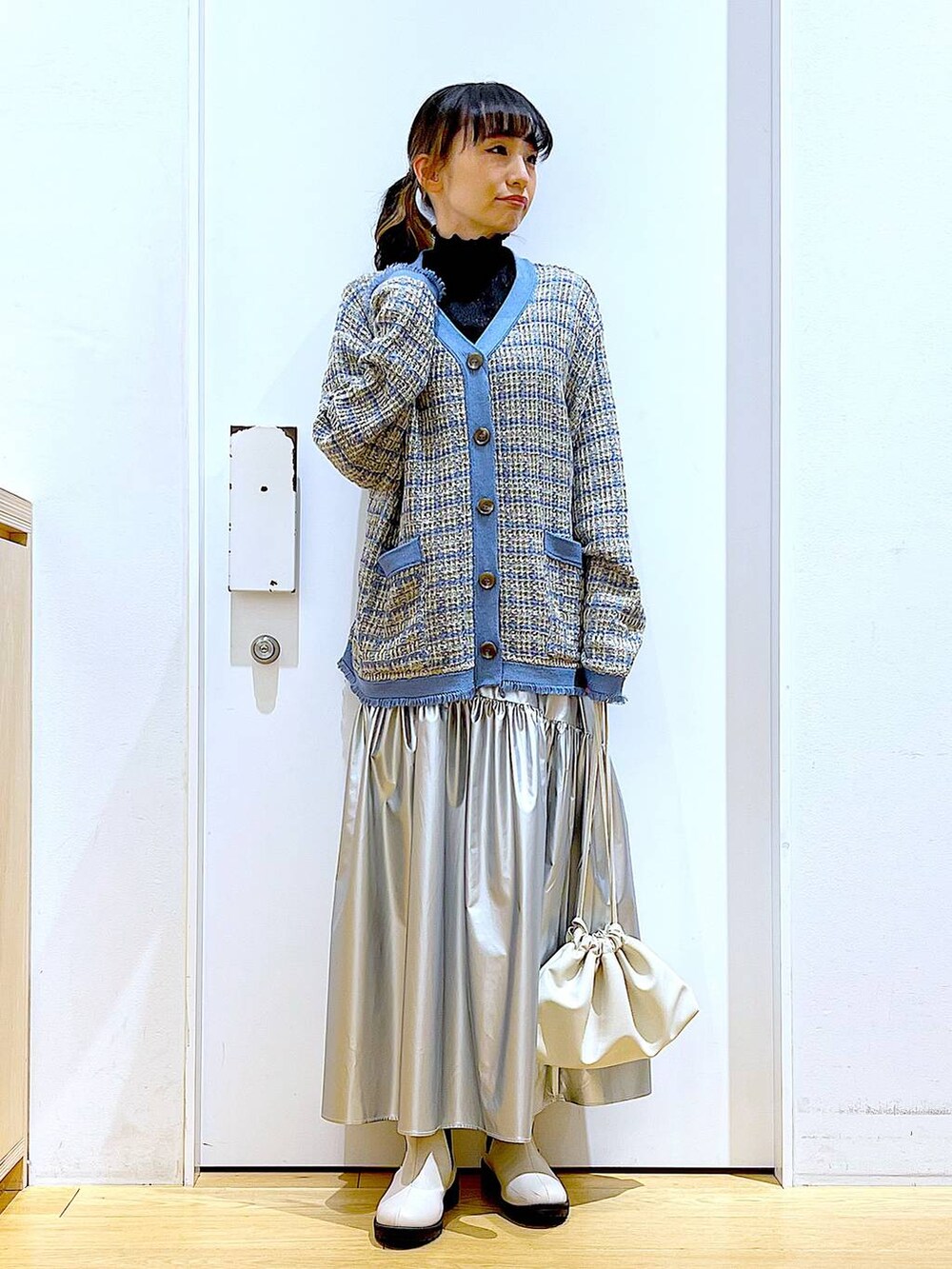 ブラック系のTシャツ/カットソー、シルバー系のスカート、ブルー系のカーディガン/ボレロを着用したレディースの冬コーディネートの2枚目の写真