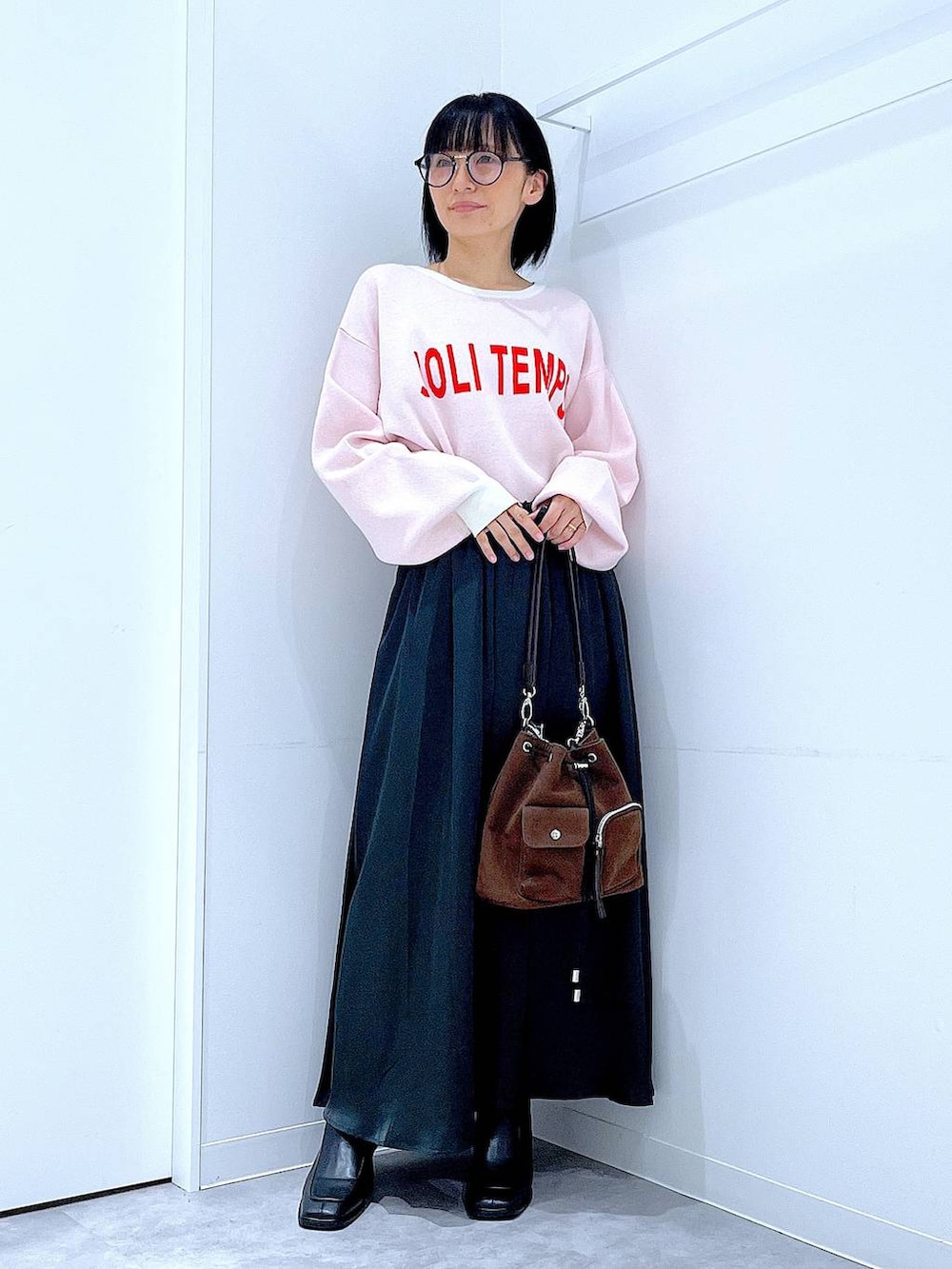 ブラウン系のショルダーバッグ、ブラック系のブーツ、ベージュ系のニット/セーターを着用したレディースの冬コーディネートの2枚目の写真