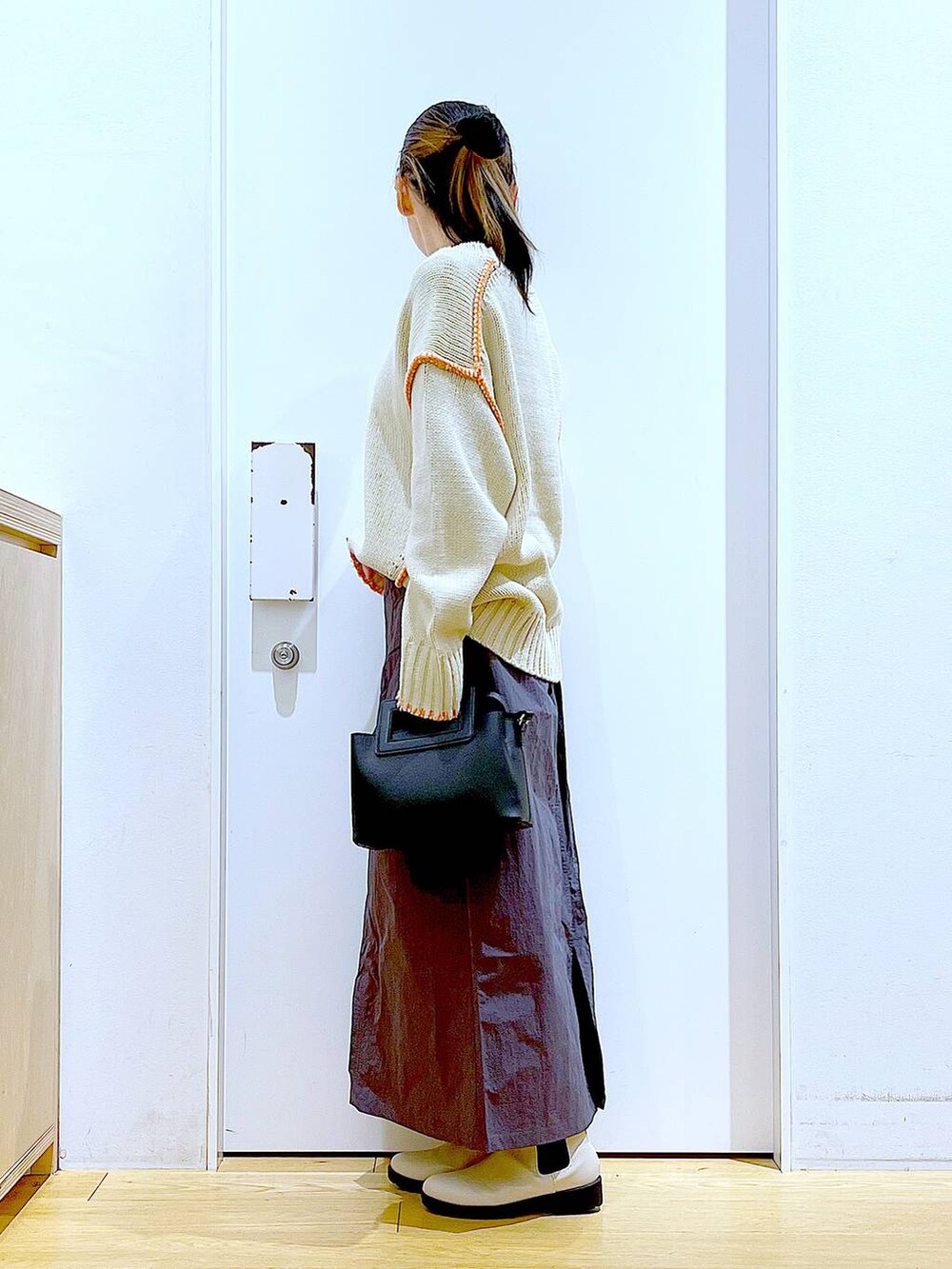 ブラック系のTシャツ/カットソー、ベージュ系のブーツ、ブラック系のショルダーバッグを着用したレディースの冬コーディネートの3枚目の写真