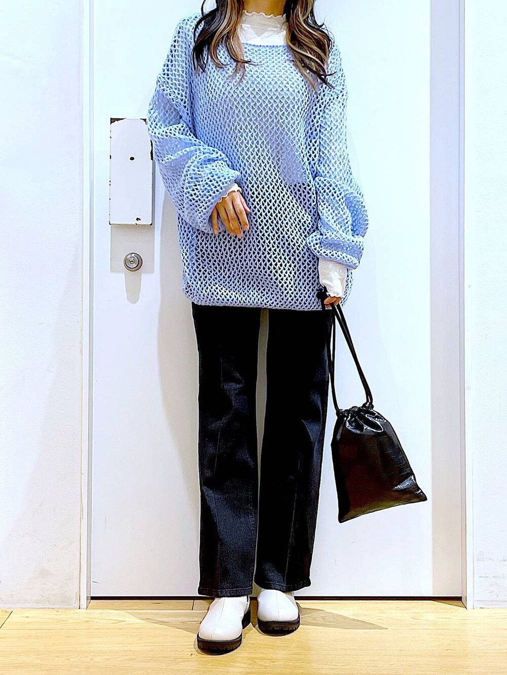 グレー系のデニムパンツ、ホワイト系のTシャツ/カットソー、ブルー系のニット/セーターを着用したレディースの冬コーディネートの6枚目の写真