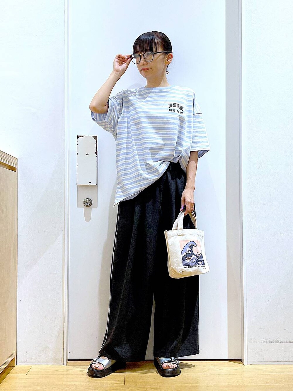 シルバー系のサンダル、その他のトートバッグ、ブルー系のTシャツ/カットソーを着用したレディースの夏コーディネートの2枚目の写真