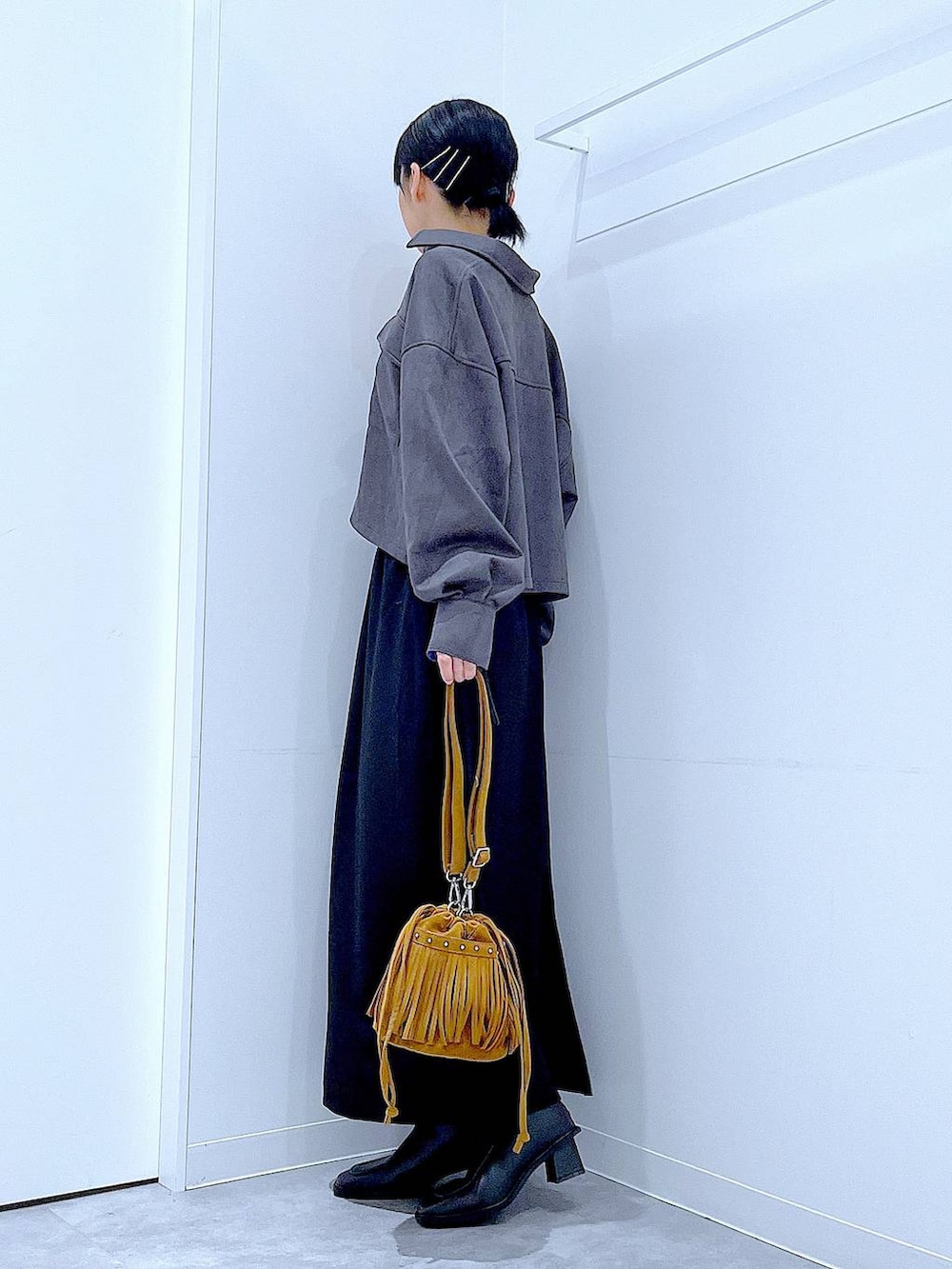 ブラック系のスカート、ブラック系のブーツ、グレー系のシャツ/ブラウスを着用したレディースの秋コーディネートの3枚目の写真