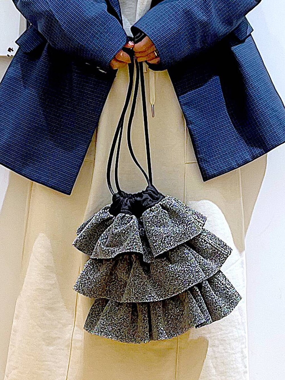 シルバー系のローファー、シルバー系のショルダーバッグ、ベージュ系のスウェットを着用したレディースの春コーディネートの9枚目の写真