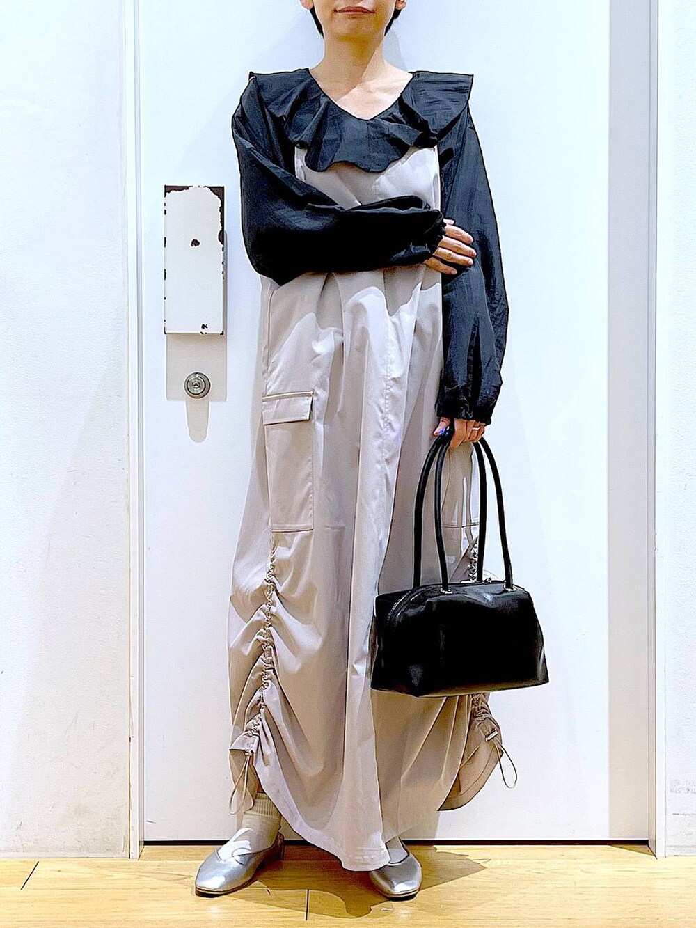 ブラック系のボストンバッグ、シルバー系のパンプス、グレー系のシャツ/ブラウスを着用したレディースの春コーディネートの6枚目の写真