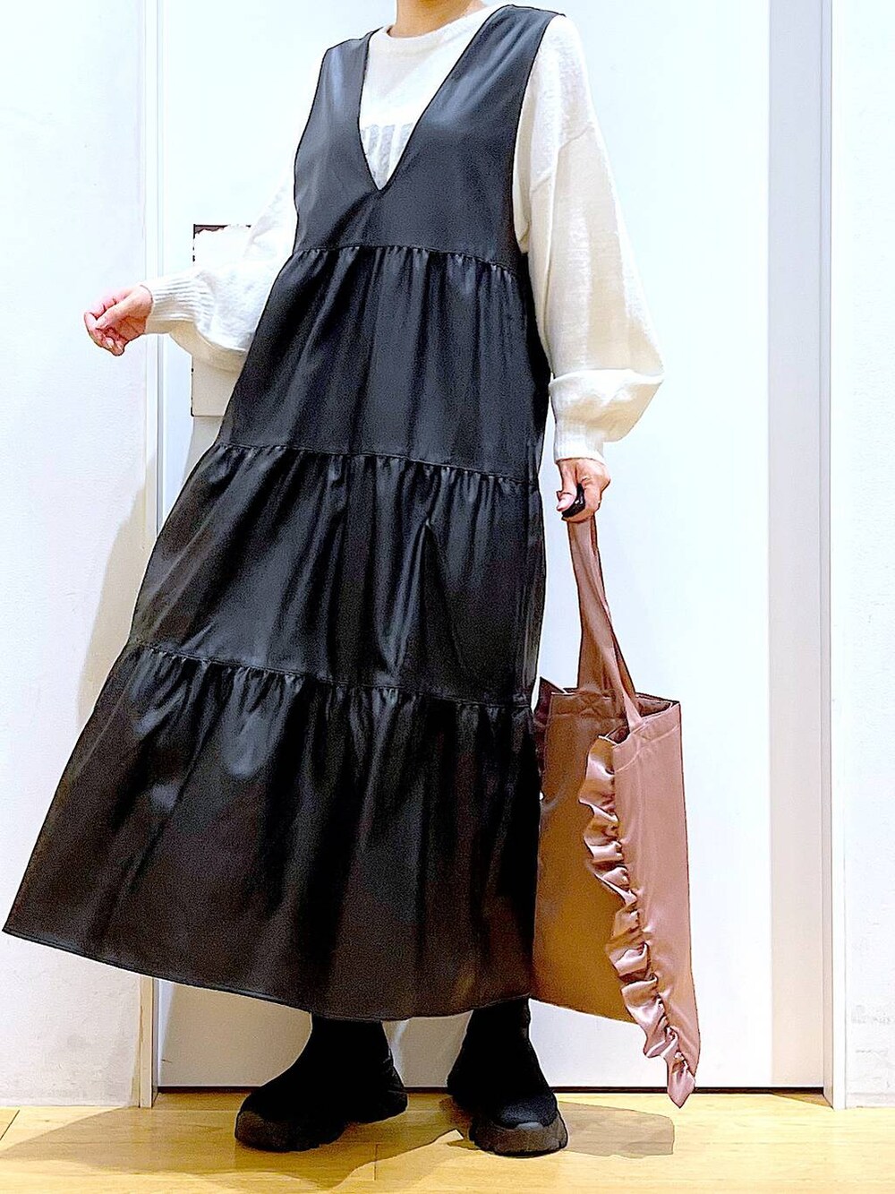 ブラック系のブーツ、ブラック系のワンピース、ピンク系のトートバッグを着用したレディースの冬コーディネートの6枚目の写真