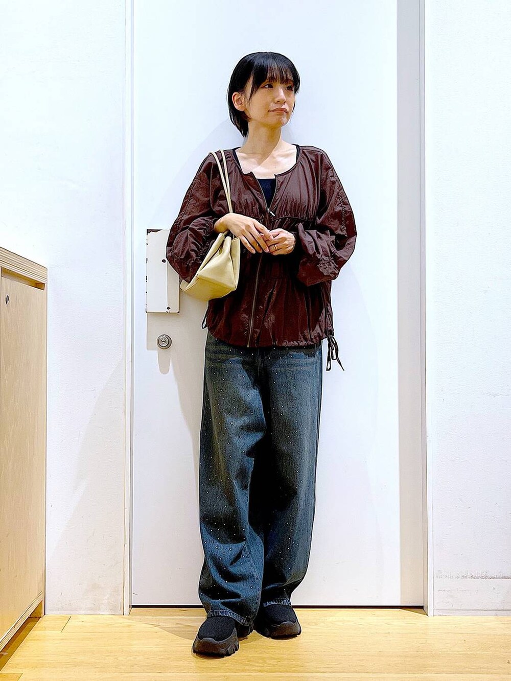 ブラック系のブーツ、ベージュ系のトートバッグ、ブラウン系のブルゾンを着用したレディースの冬コーディネートの2枚目の写真