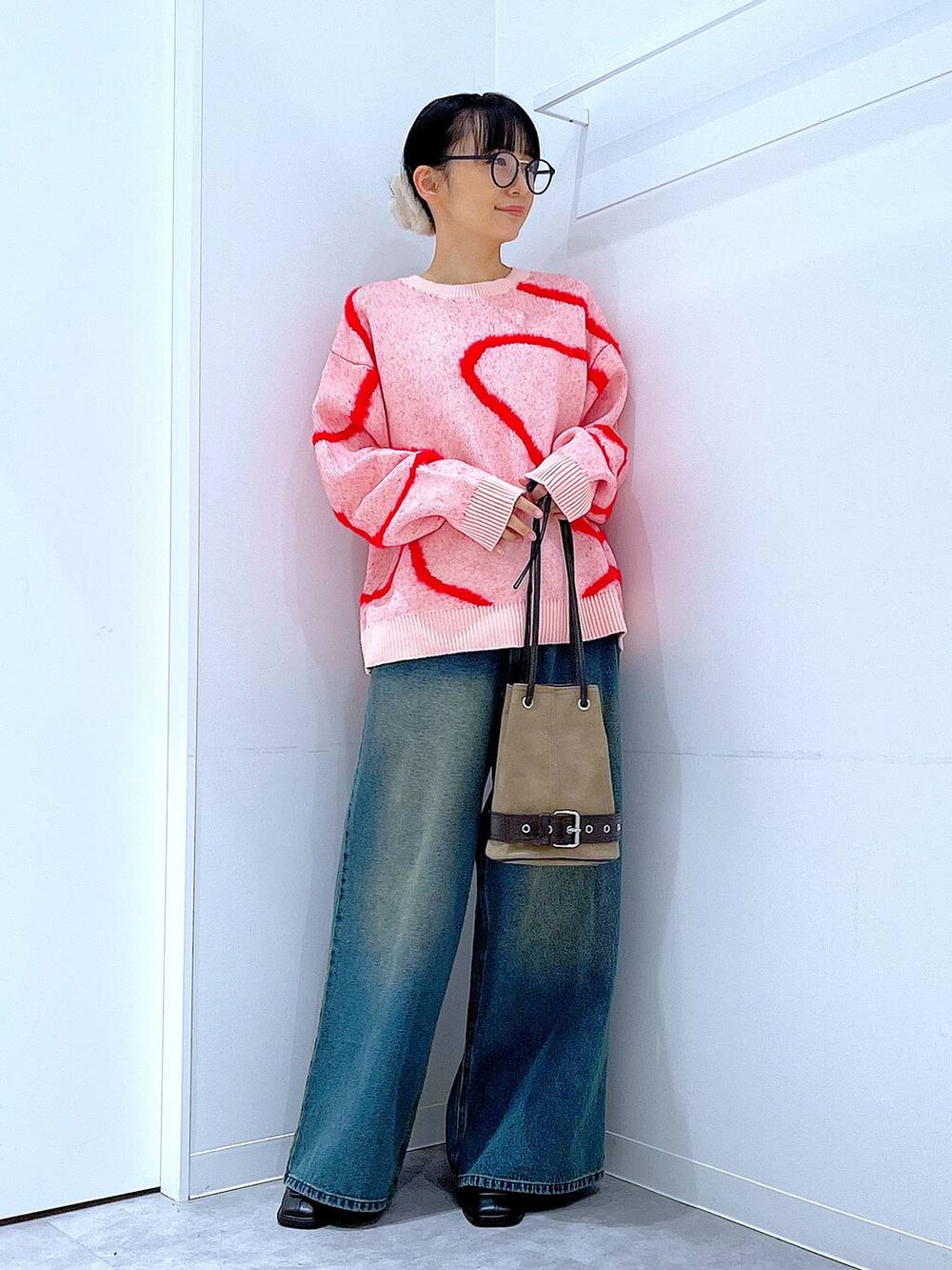 ブルー系のデニムパンツ、ブラック系のブーツ、ベージュ系のハンドバッグを着用したレディースの冬コーディネートの2枚目の写真