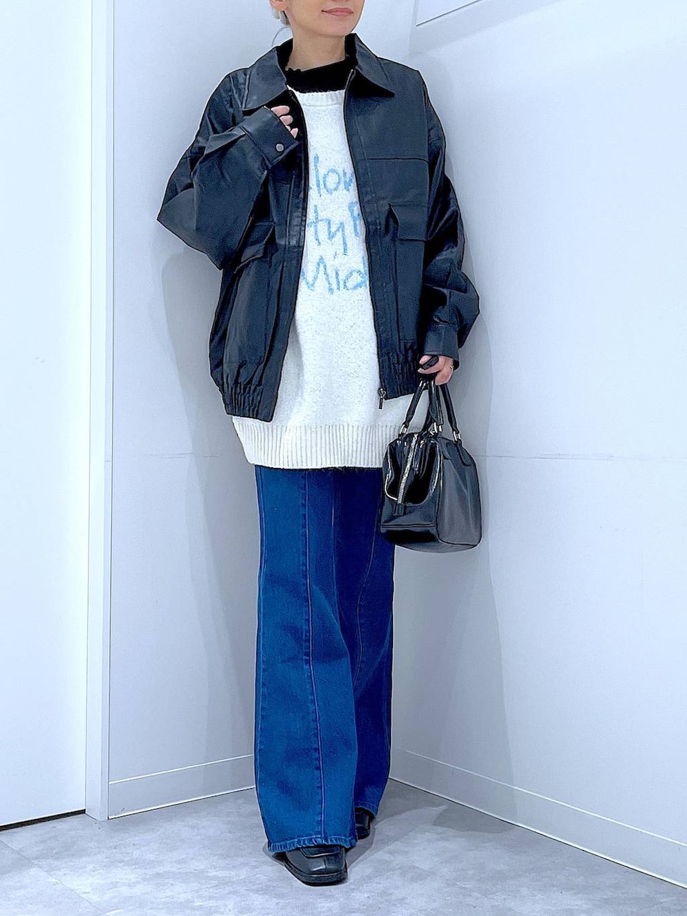 ブラック系のブルゾン、ブラック系のブーツ、ブラック系のショルダーバッグを着用したレディースの冬コーディネートの6枚目の写真