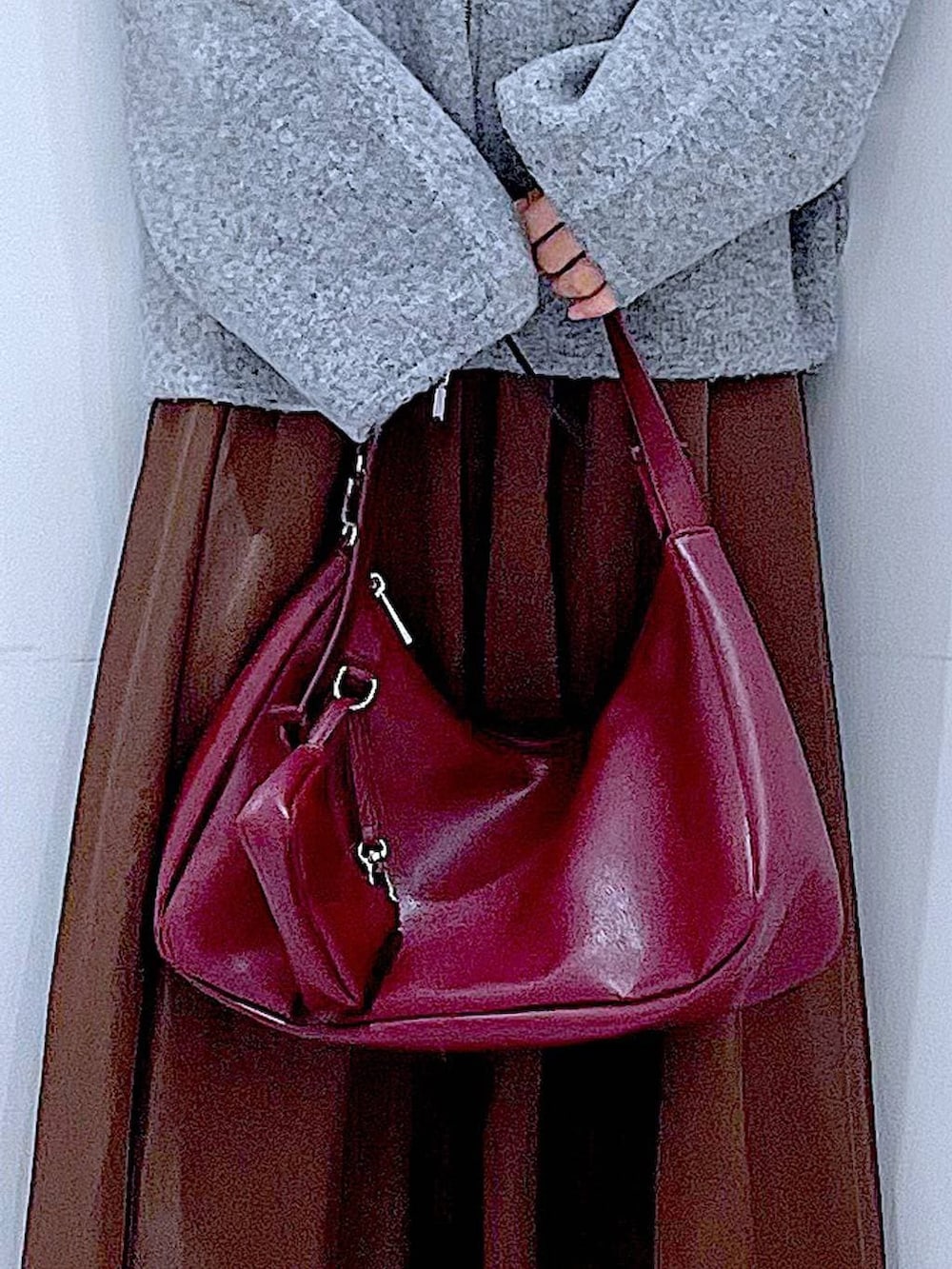 グレー系のブルゾン、ブラック系のブーツ、レッド系のショルダーバッグを着用したレディースの冬コーディネートの9枚目の写真