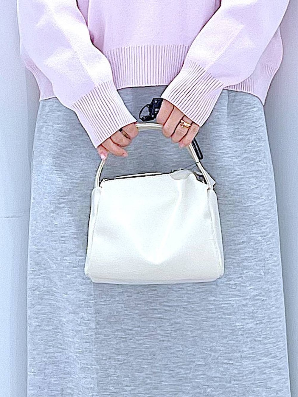 ホワイト系のショルダーバッグ、ピンク系のニット/セーター、グレー系のスカートを着用したレディースの冬コーディネートの9枚目の写真