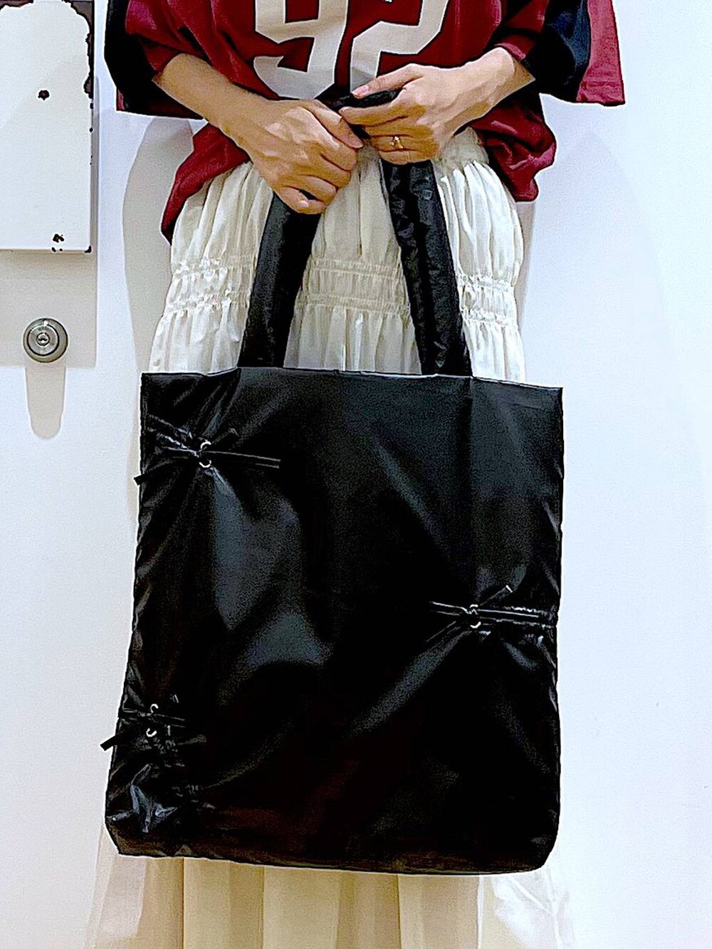 ホワイト系のスカート、ブラック系のスニーカー、ブラック系のトートバッグを着用したレディースの秋コーディネートの9枚目の写真