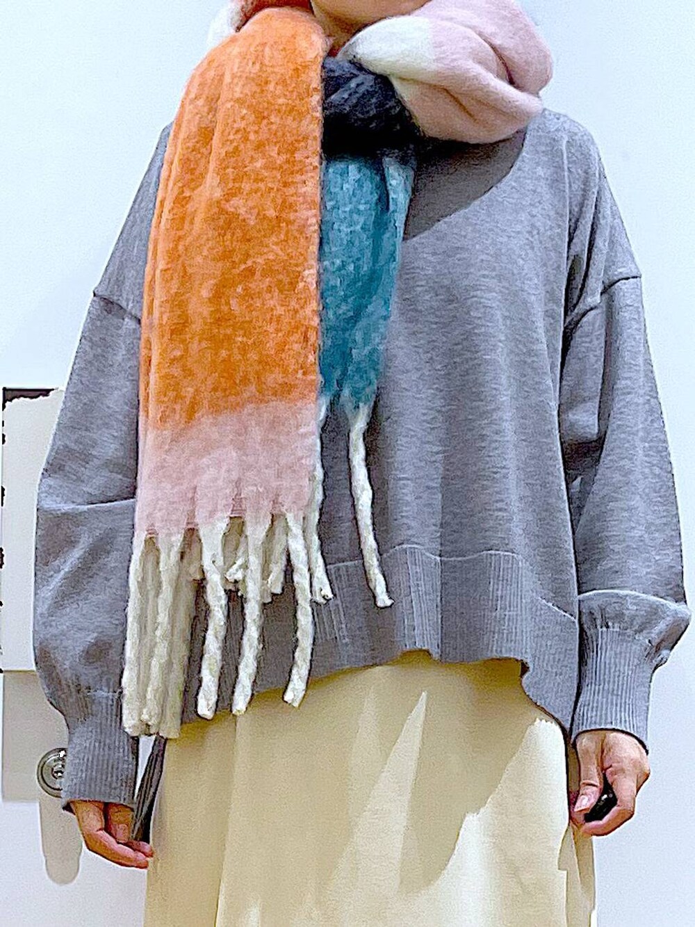 ブラック系のブーツ、ホワイト系のスカート、グレー系のニット/セーターを着用したレディースの冬コーディネートの7枚目の写真