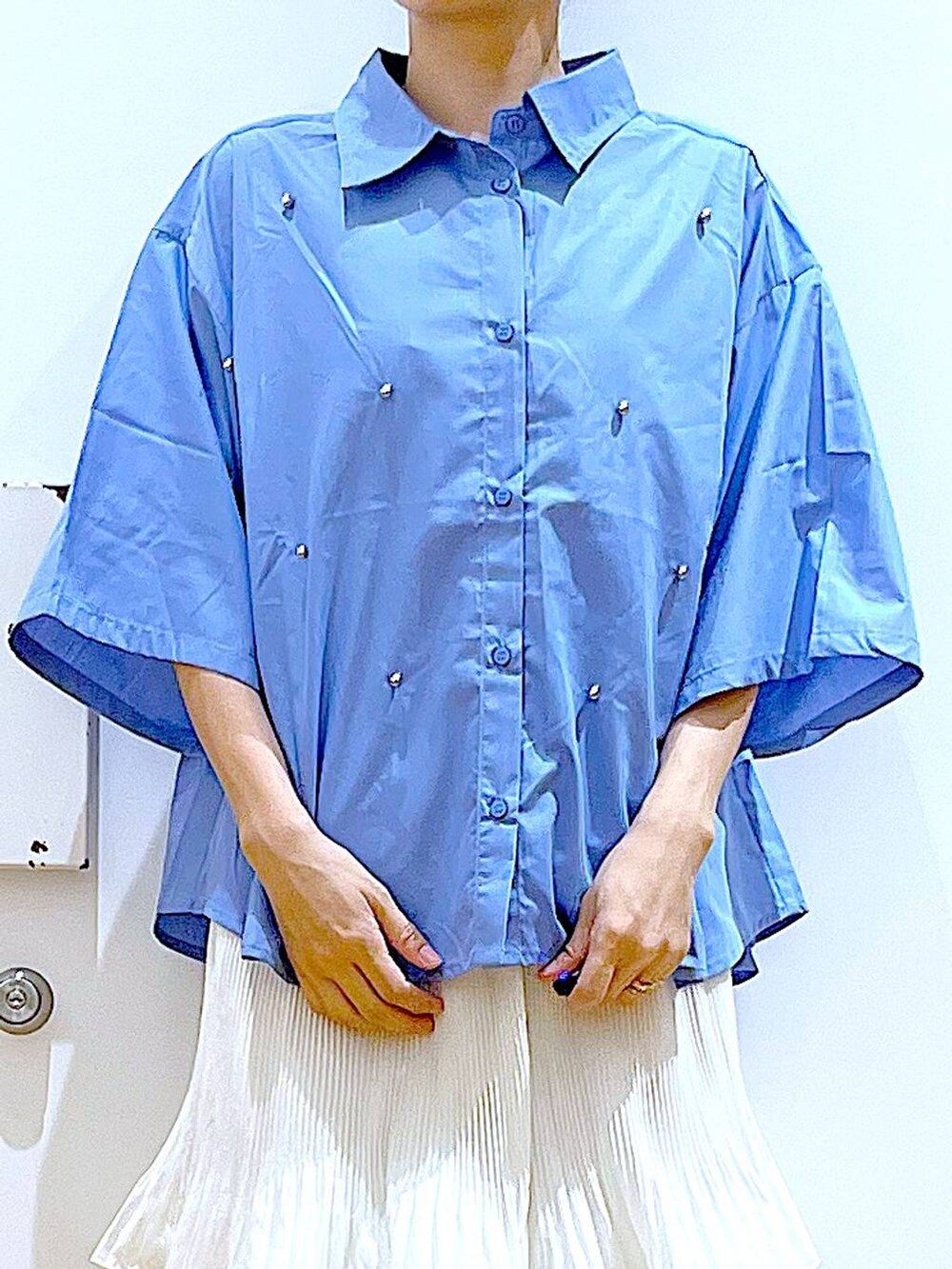 ベージュ系のスカート、ブルー系のトートバッグ、ホワイト系のサンダルを着用したレディースの夏コーディネートの7枚目の写真