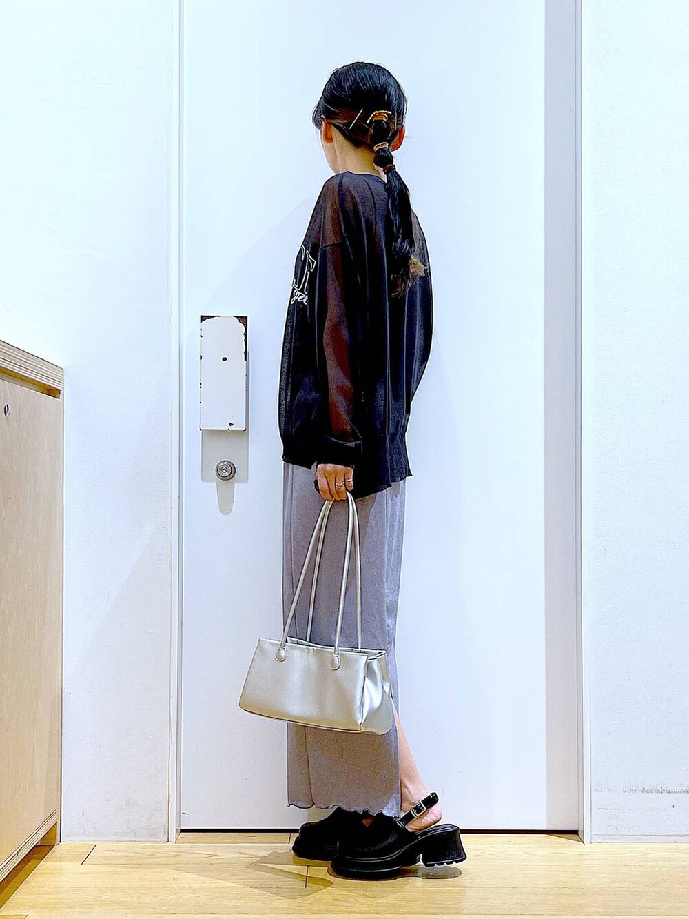 パープル系のスカート、ブラック系のサンダル、グレー系のニット/セーターを着用したレディースの春コーディネートの3枚目の写真