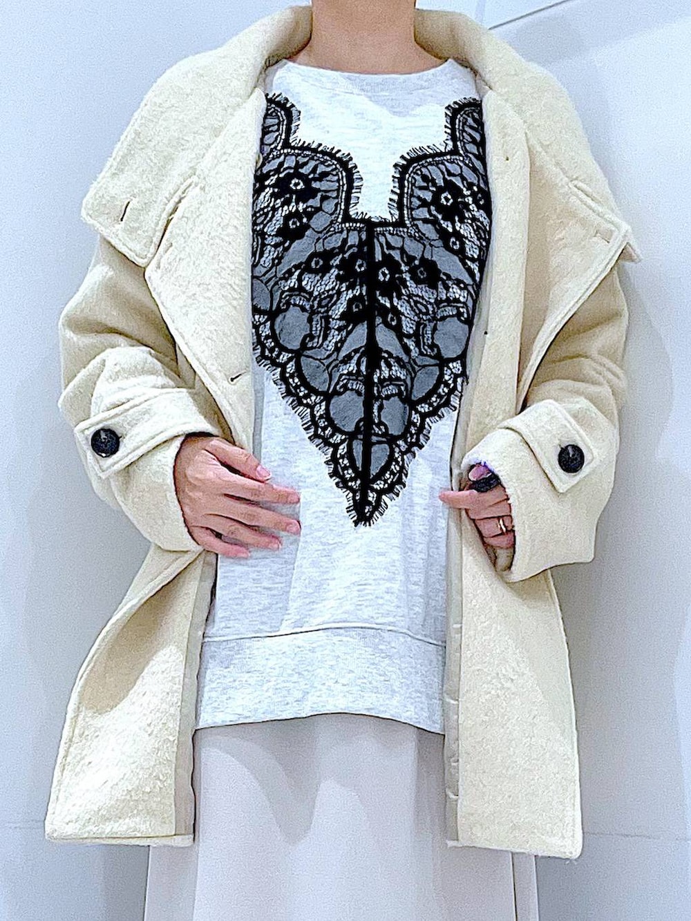 ベージュ系のスカート、ベージュ系のステンカラーコート、ブラック系のブーツを着用したレディースの冬コーディネートの7枚目の写真