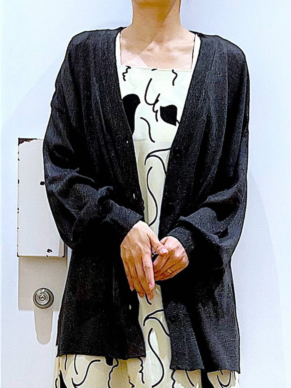 ブルー系のデニムパンツ、ベージュ系のワンピース、シルバー系のショルダーバッグを着用したレディースの春コーディネートの7枚目の写真