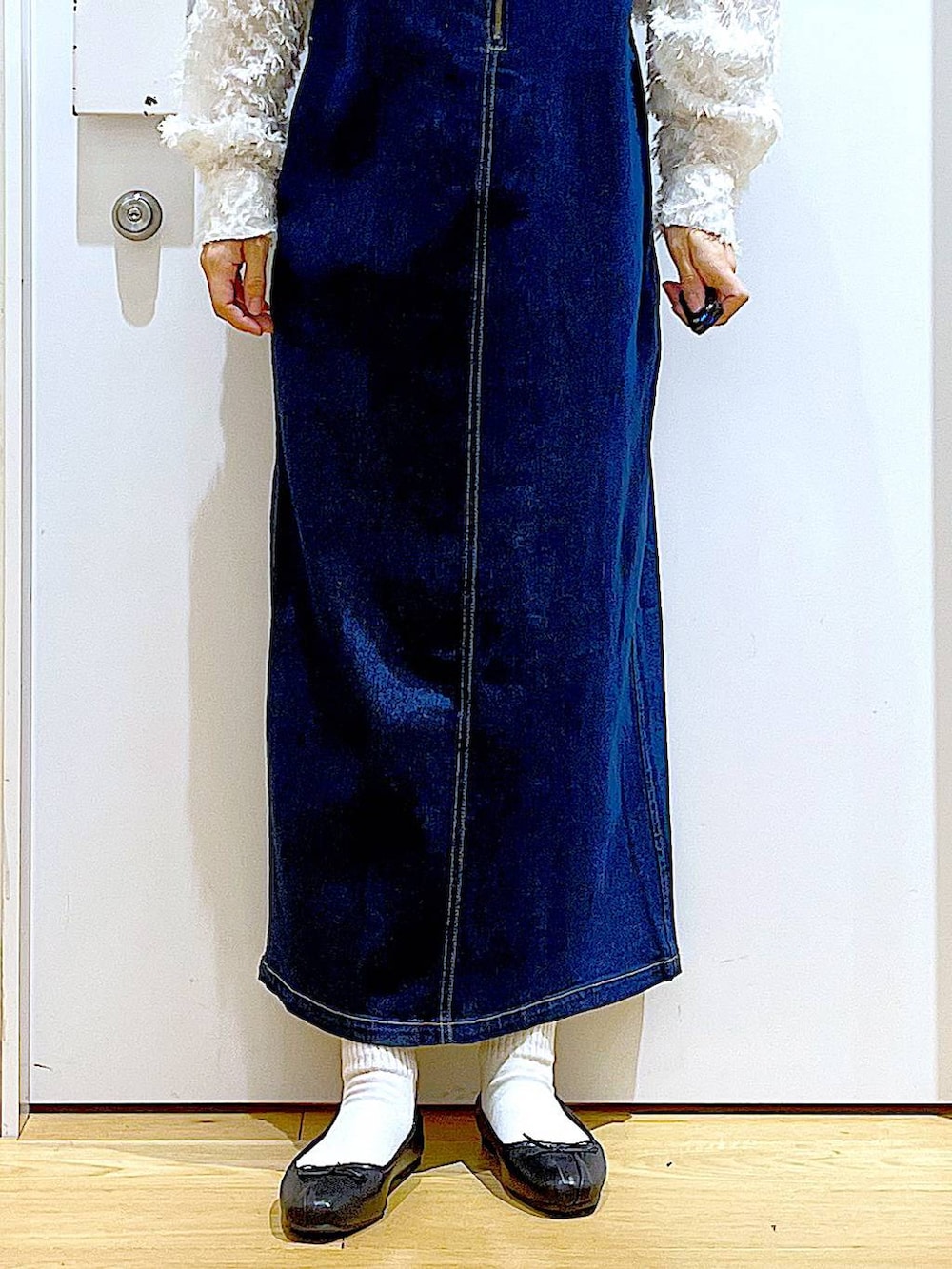 グレー系のショルダーバッグ、ブラック系のバレエシューズ、ブルー系のジャンパースカートを着用したレディースの春コーディネートの8枚目の写真