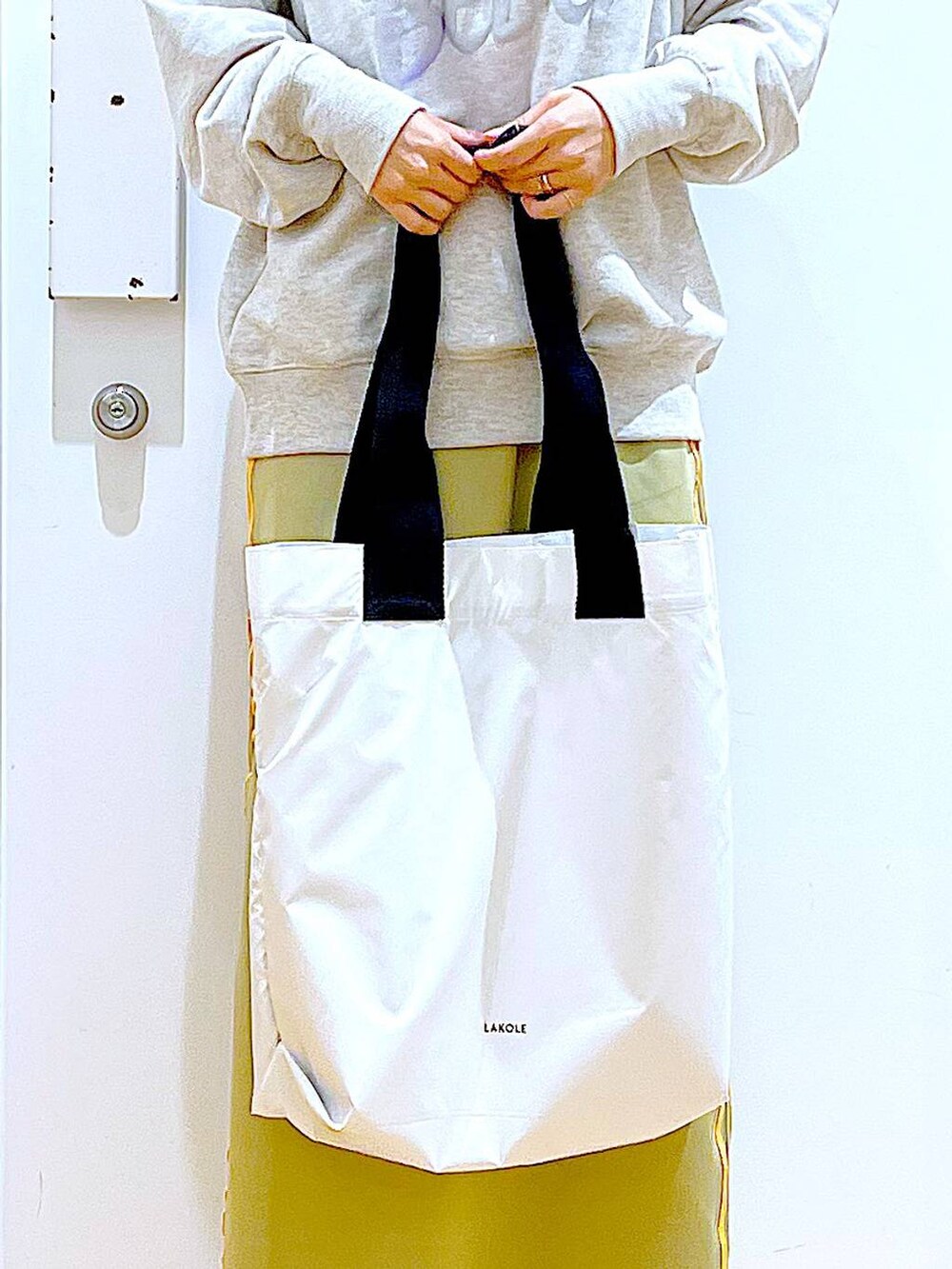 ベージュ系のスウェット、ベージュ系のブーツ、ホワイト系のトートバッグを着用したレディースの冬コーディネートの9枚目の写真