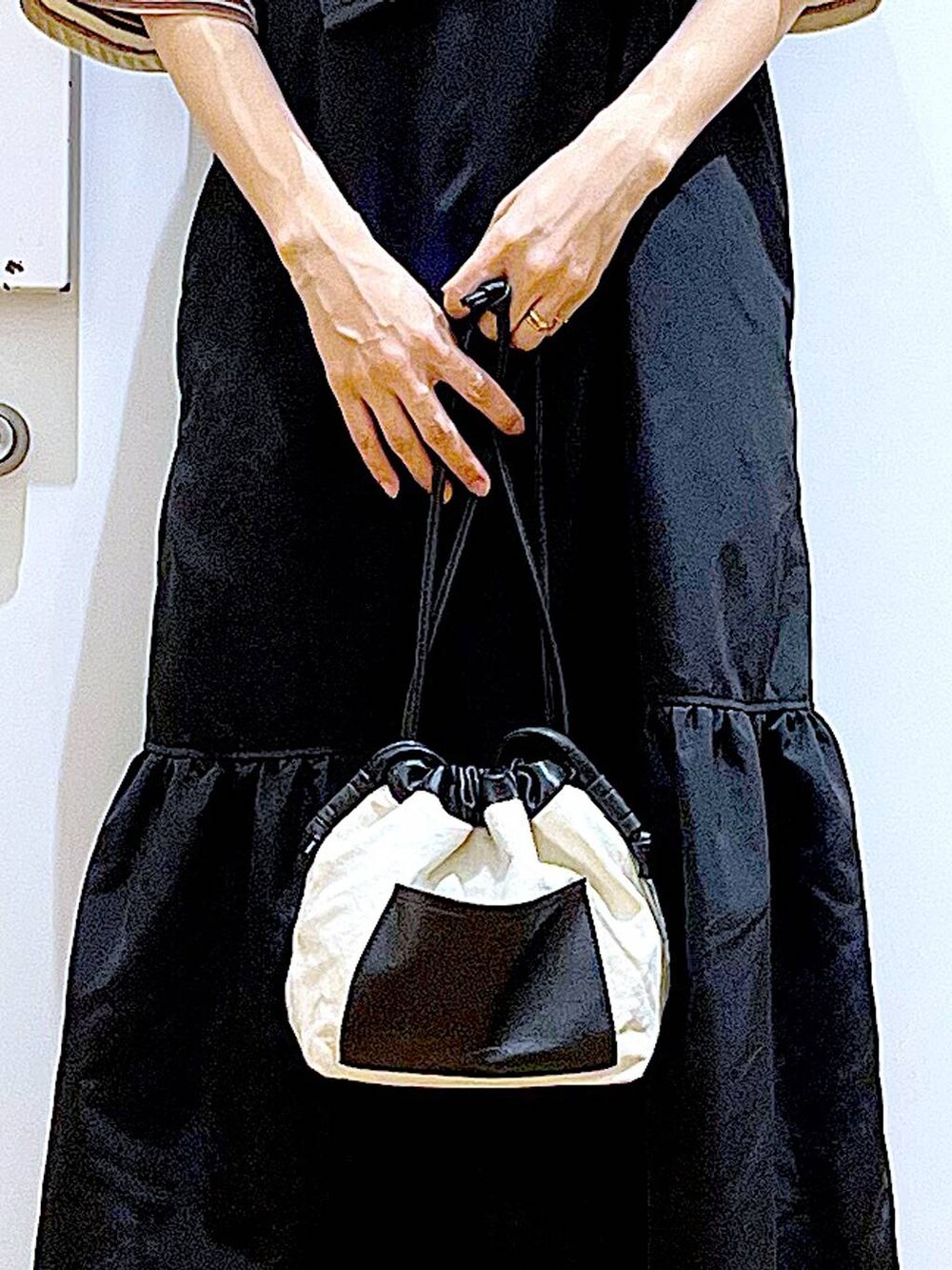 ホワイト系のショルダーバッグ、ブラック系のワンピース、ベージュ系のサンダルを着用したレディースの春コーディネートの9枚目の写真