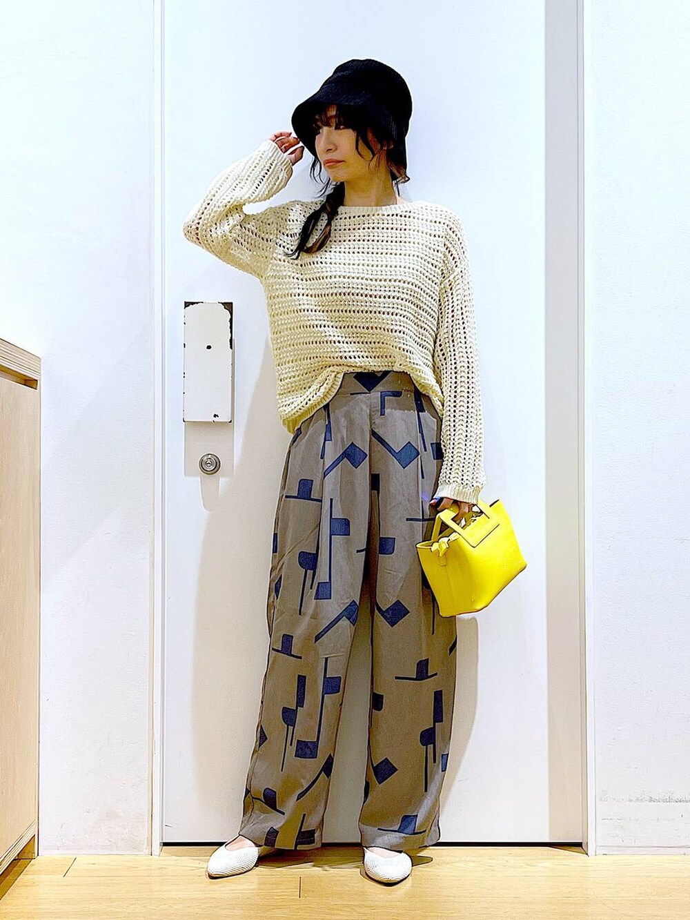 ホワイト系のニット/セーター、イエロー系のショルダーバッグ、ホワイト系のパンプスを着用したレディースの春コーディネートの2枚目の写真