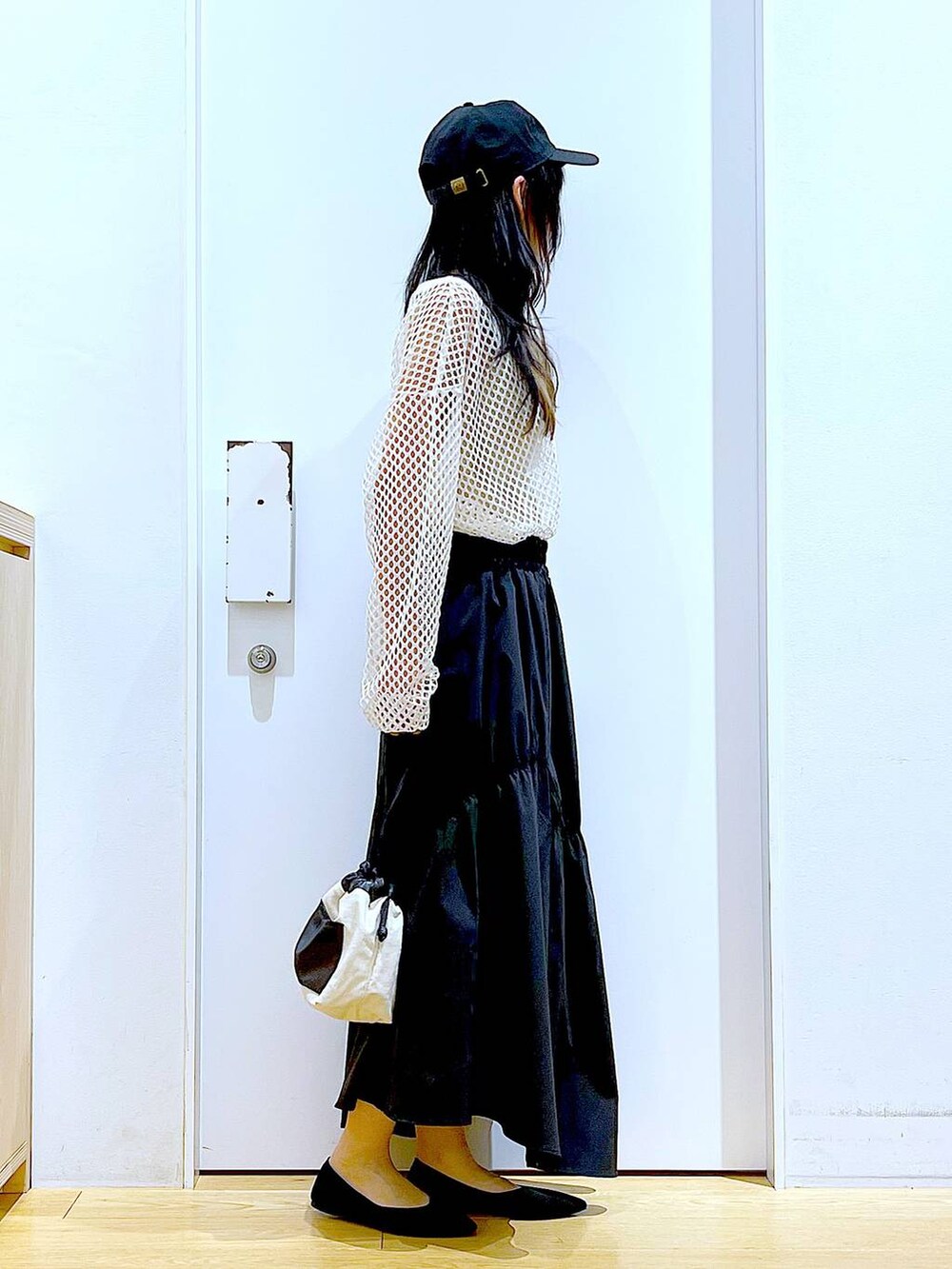 ホワイト系のTシャツ/カットソー、ホワイト系のショルダーバッグ、イエロー系のニット/セーターを着用したレディースの春コーディネートの4枚目の写真