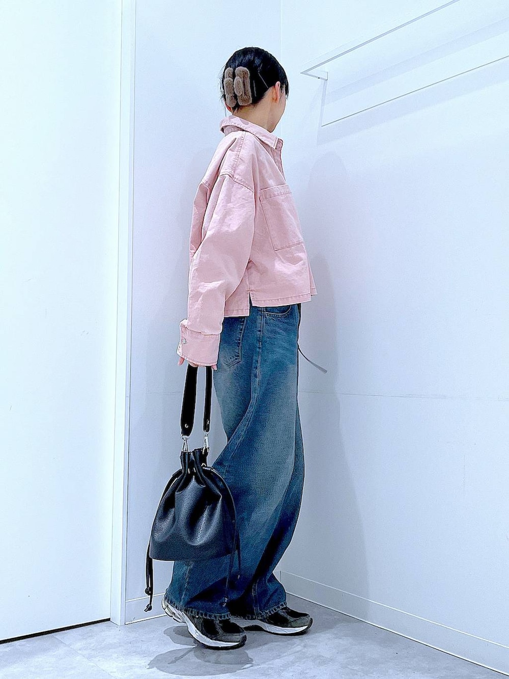 ブルー系のデニムパンツ、ピンク系のシャツ/ブラウス、ブラック系のショルダーバッグを着用したレディースの冬コーディネートの4枚目の写真